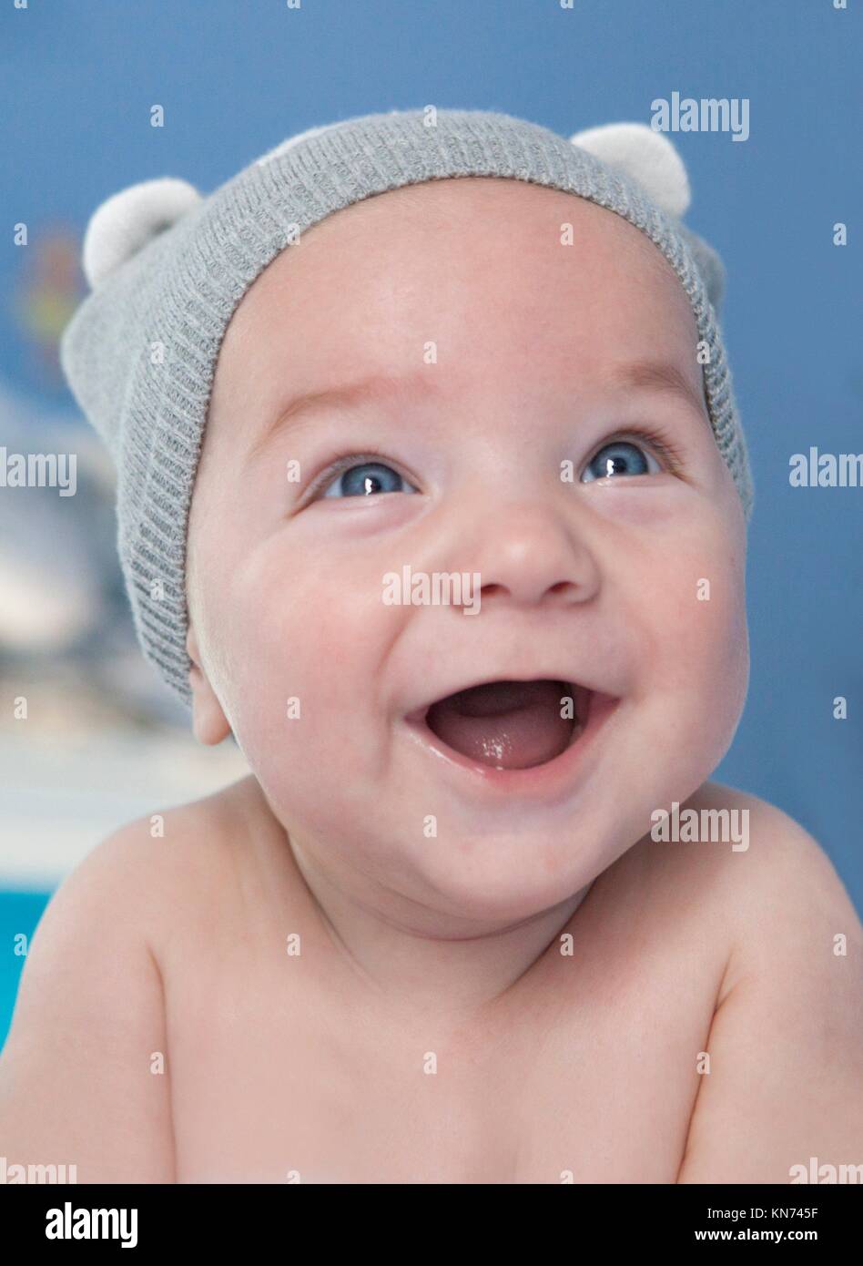 Portrait of a four months old baby smiling. He is faced down. Stock Photo