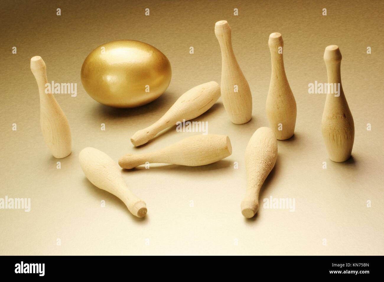 Golden egg and bowling pins Stock Photo Alamy