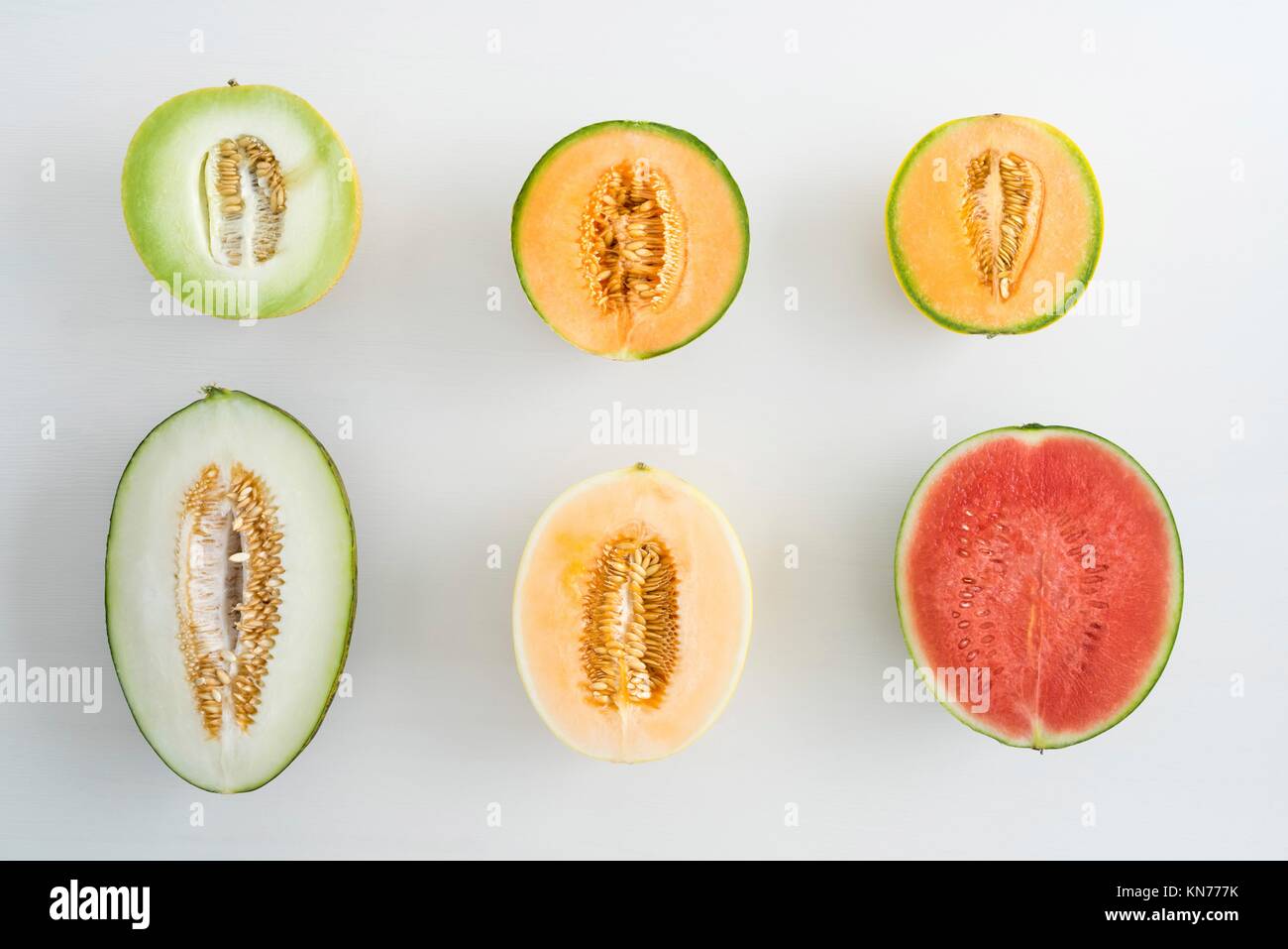 Overhead shot of a collection of different melons cut in half Stock