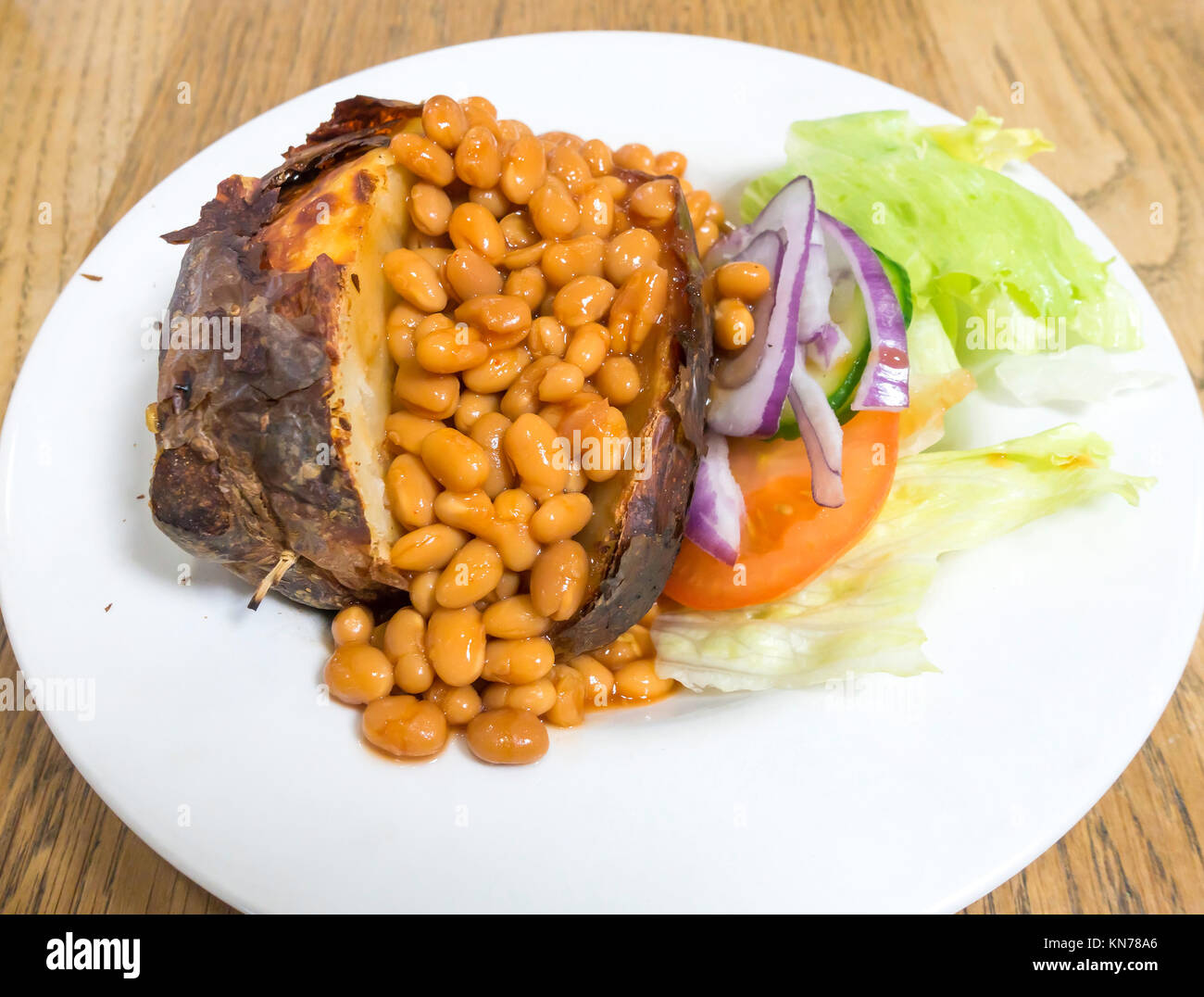 Cheap wholesome lunch jacket potato baked beans and salad Stock Photo