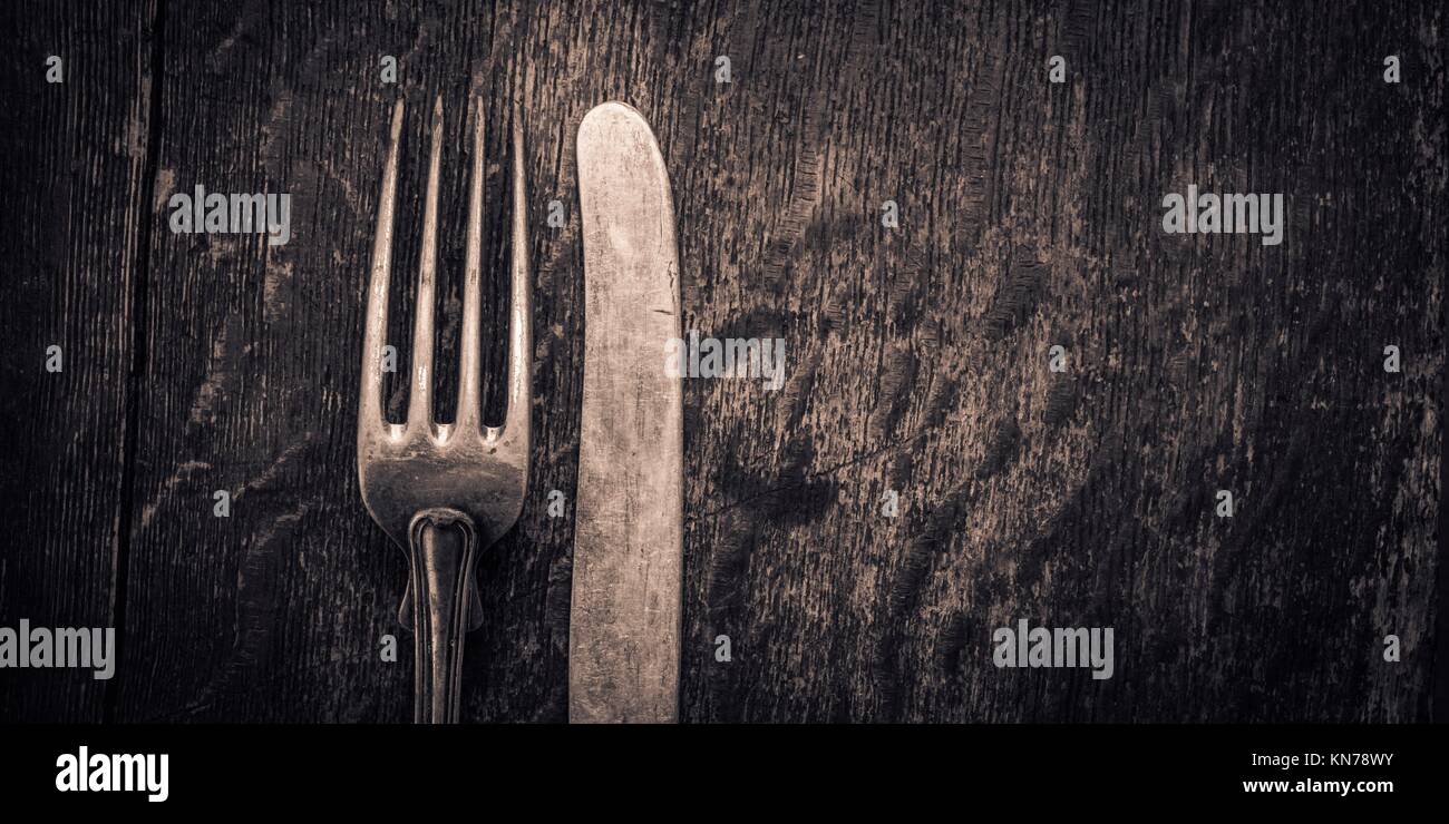 Close up of retro cutlery on rustic wooden background. Conceptual image of cooking, eating food and kitchen objects. Stock Photo
