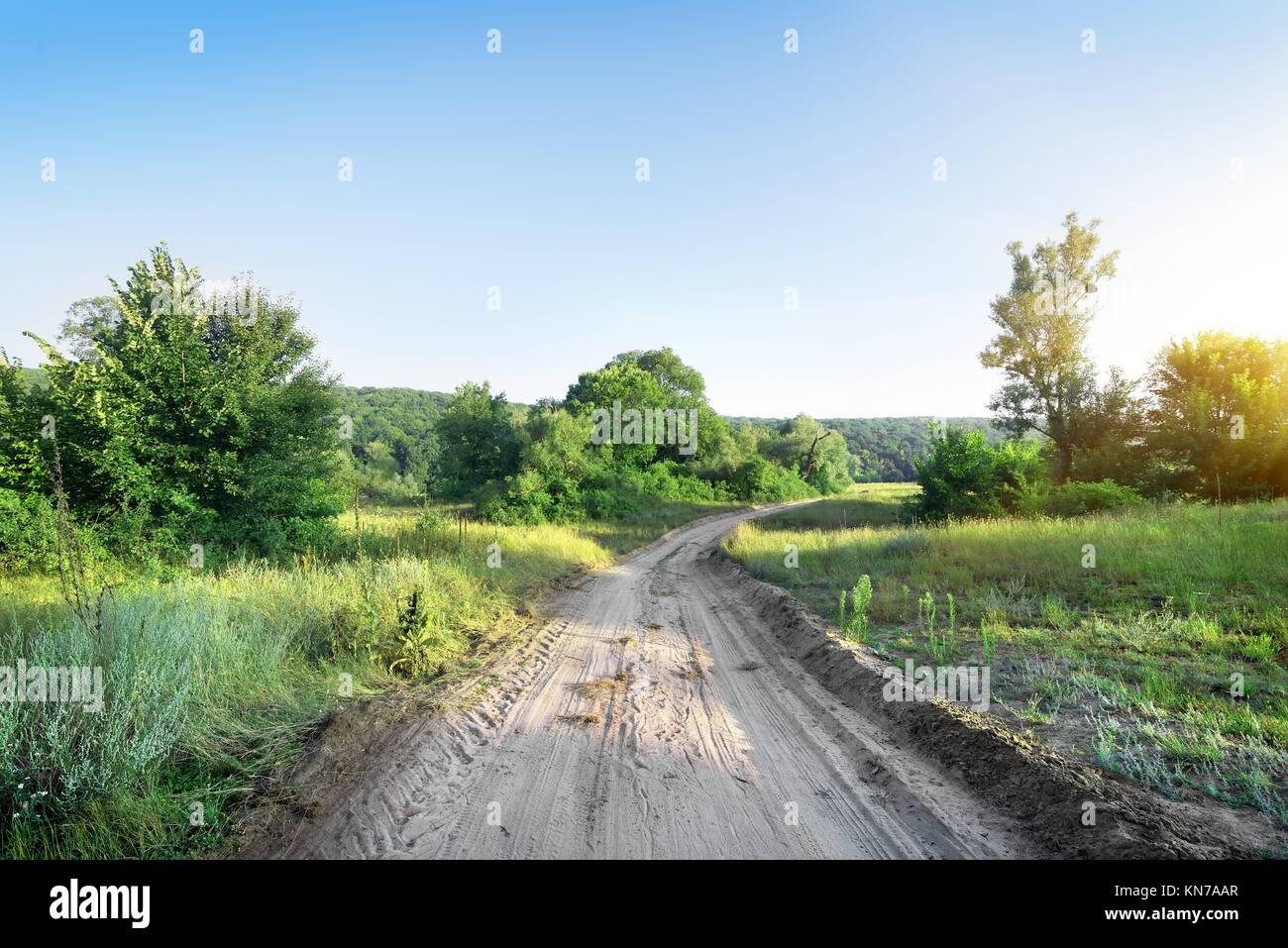 Road in the field at the sunrise Stock Photo - Alamy