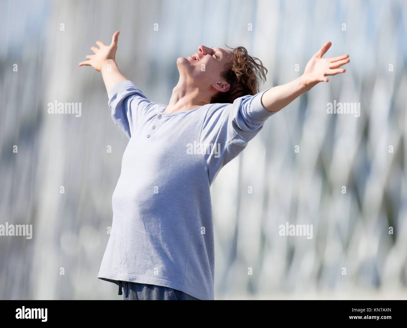 Excited Young Man Stretching out his Arm in Emotion Outdoors. Stock Photo