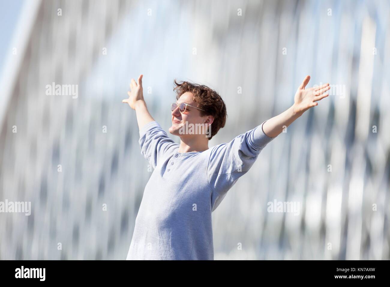Excited Young Man Stretching out his Arm in Emotion Outdoors. Stock Photo