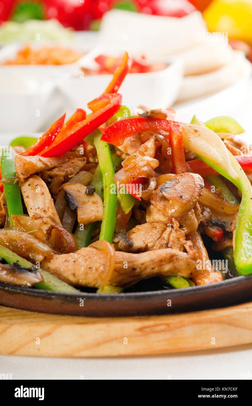 original fajita sizzling smoking hot served on iron plate and fresh vegetables on background
