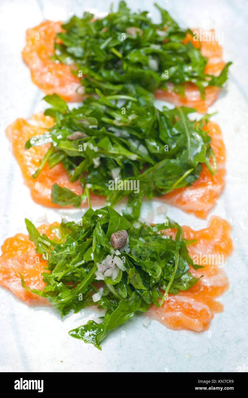 fresh salmon carpaccio sushi sashimi with arugula rocket salad and