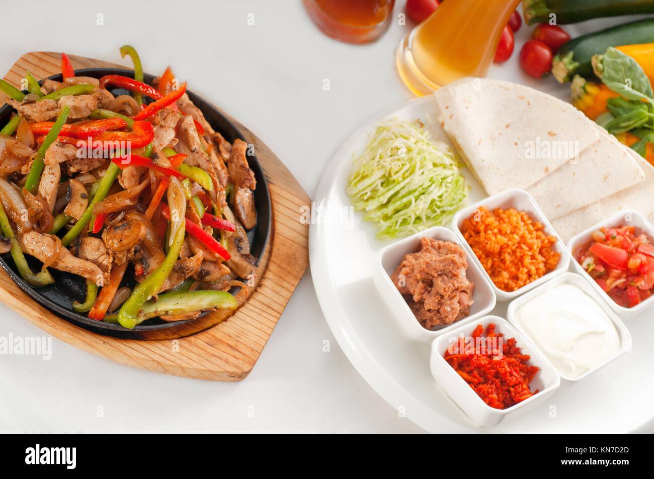 original fajita sizzling smoking hot served on iron plate and fresh vegetables on background