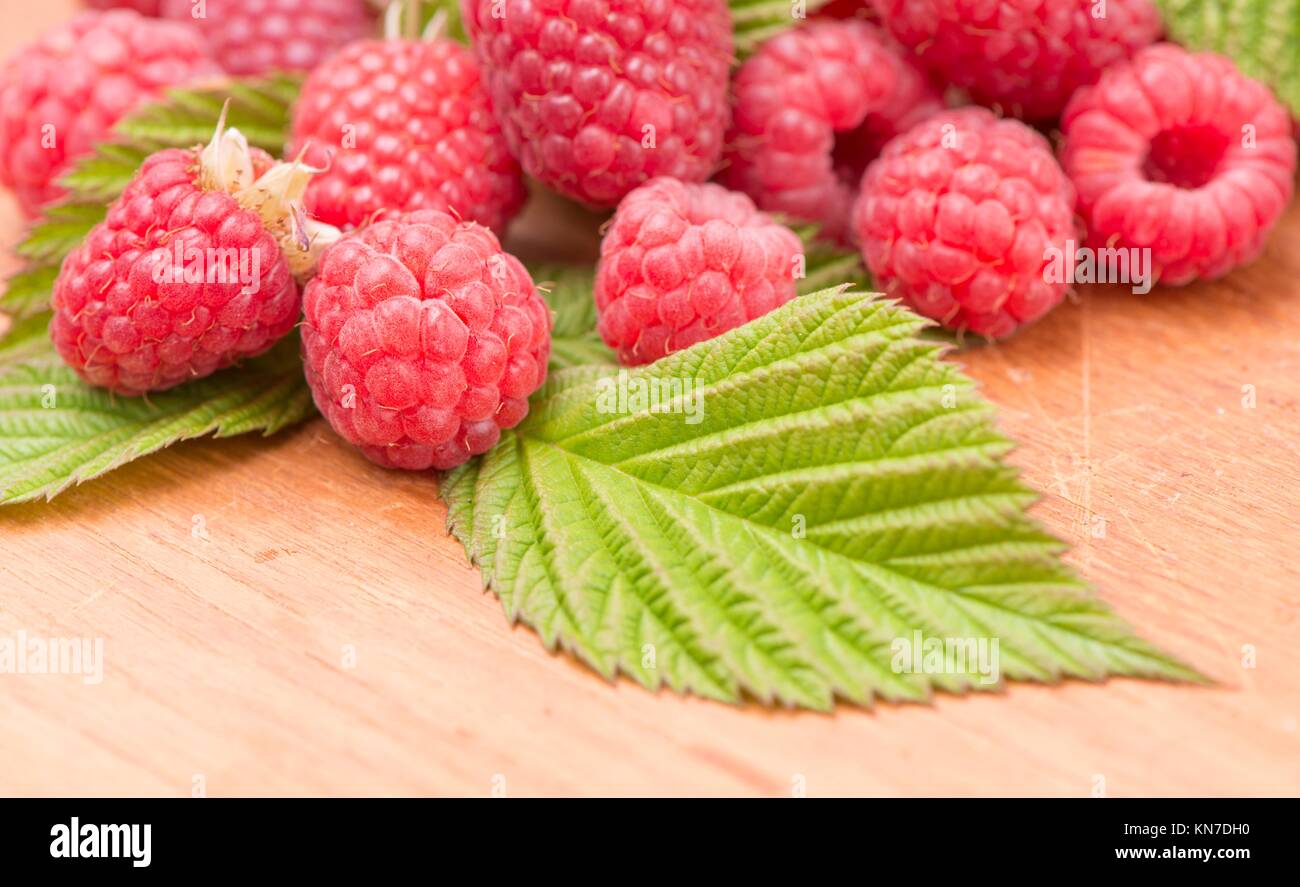 Raspberries in close-up. They are fresh, ripe and red. Tasty food image with juicy berries. Stock Photo