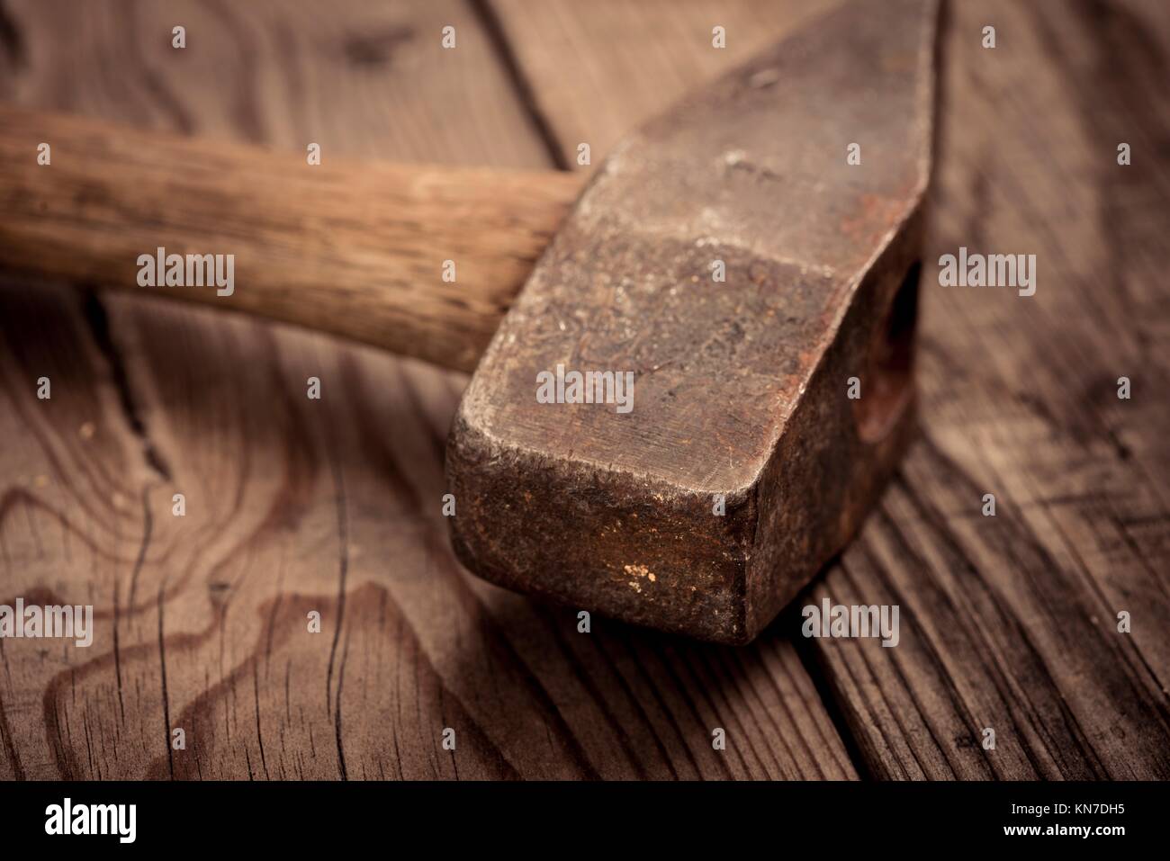 Vintage hammer lying on wooden surface of workbench. Conceptual image of home improvement, DIY and carpentry. Stock Photo