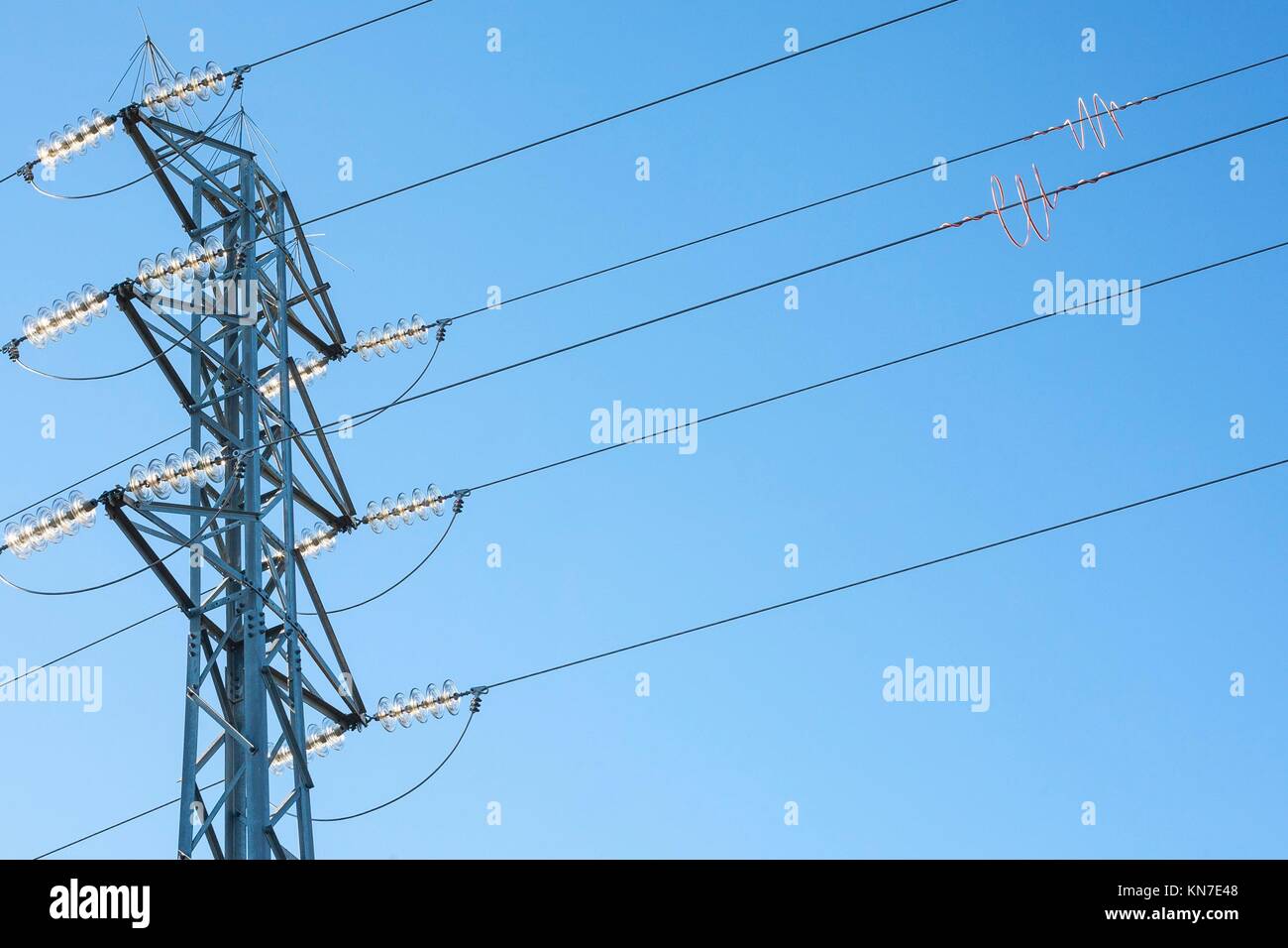 High voltage power pylons against blue sky. Low view. Stock Photo