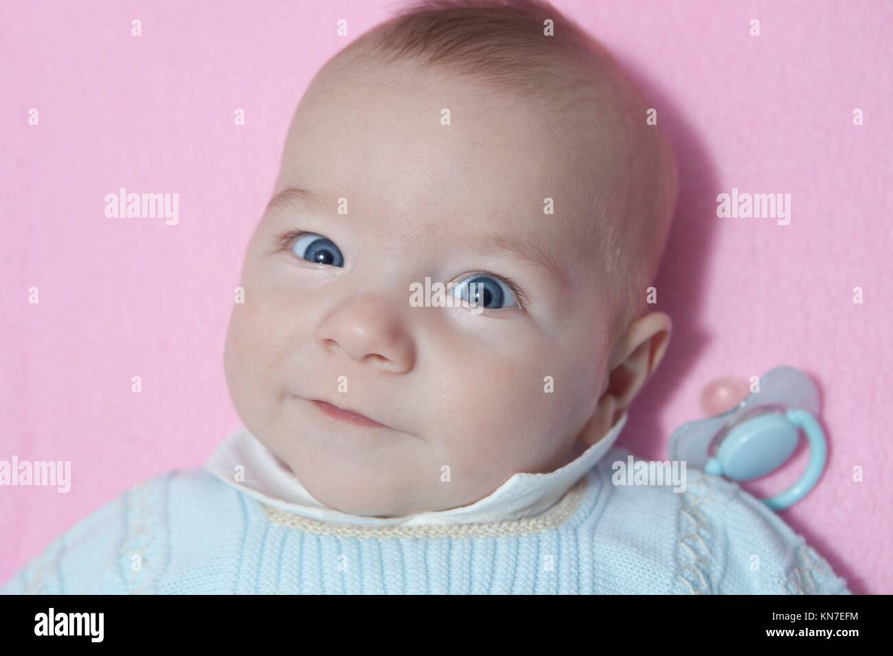 Awake four month baby boy lying in cot with dummy out. Overhead view