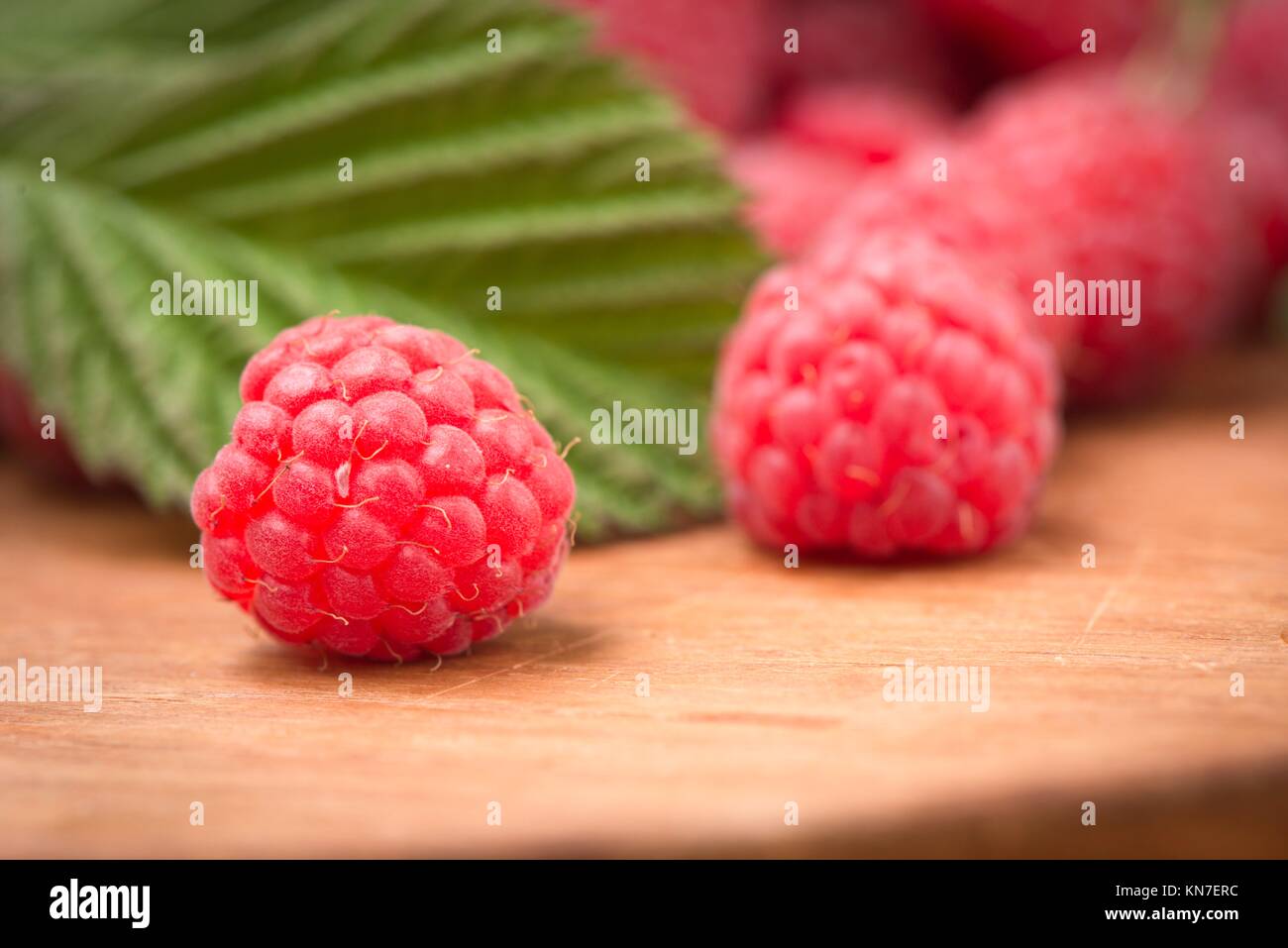 Raspberries in close-up. They are fresh, ripe and red. Tasty food image with juicy berries. Stock Photo