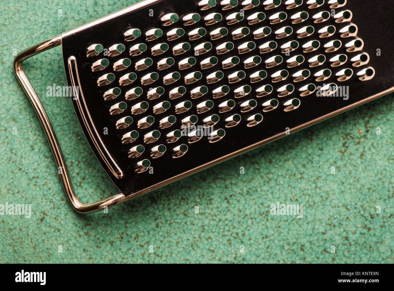 Stainless steel grater in close-up. Kitchen appliance used for grating in food preparation. Stock Photo