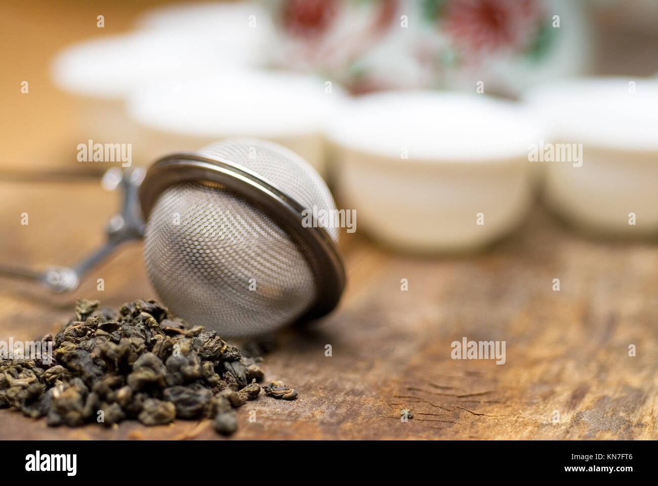 dry green chinese tea set,with strainer closeup,cups and teapot on