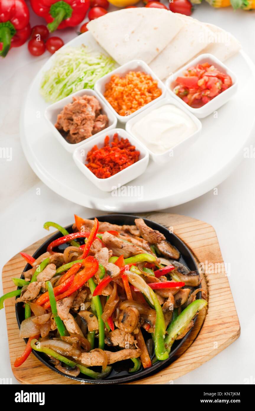 original fajita sizzling smoking hot served on iron plate and fresh vegetables on background