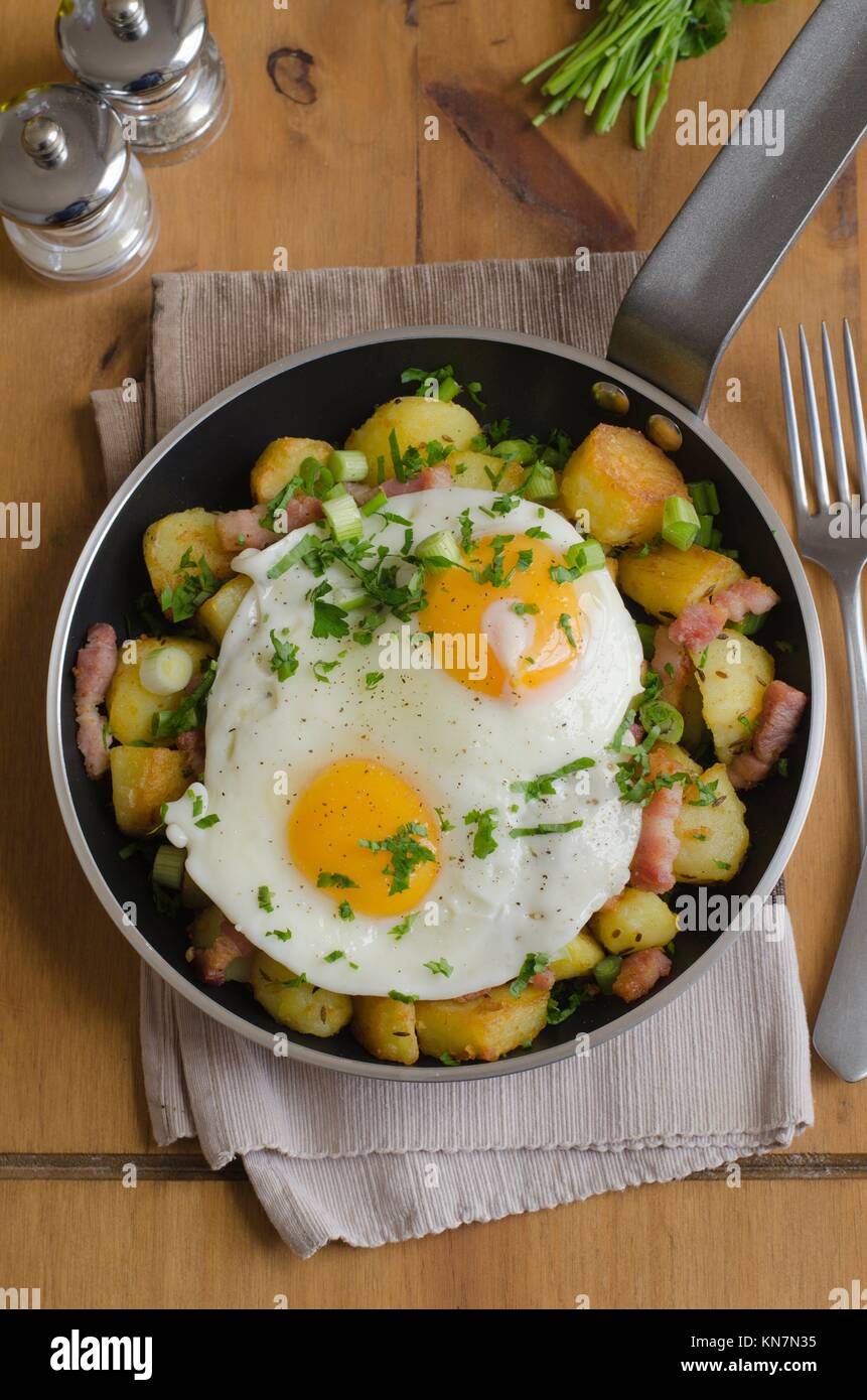Fried eggs with roasted potatoes and bacon lardons Stock Photo Alamy