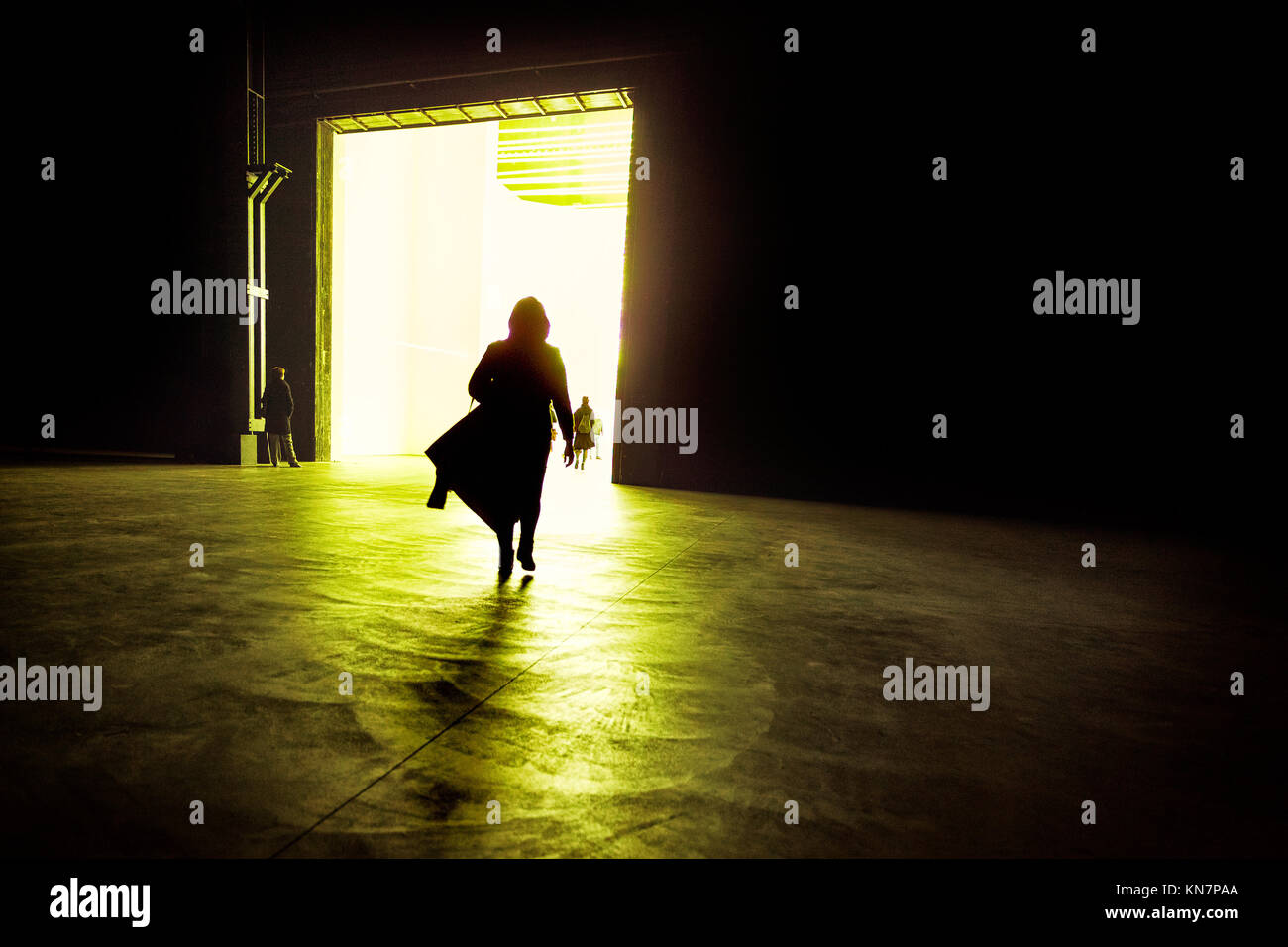 Silhouette of a business woman walking into the illuminated big room, Milano, Italy Stock Photo