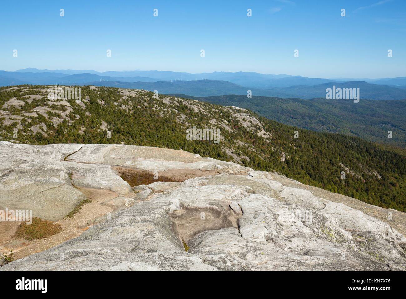 Exposed granite of the summit of Mt. Cardigan, near Grafton, New Hampshire, with a view of mountains to the southeast. Stock Photo