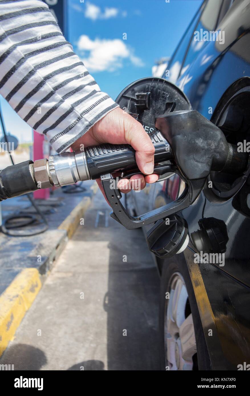 Man pumping gasoline fuel in car at gas station. Stock Photo
