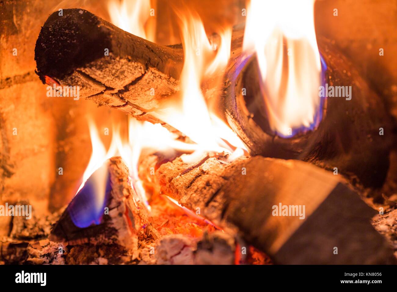 Dark pieces of wood burning in orange-yellow flame in the fire full of  ashes Stock Photo - Alamy