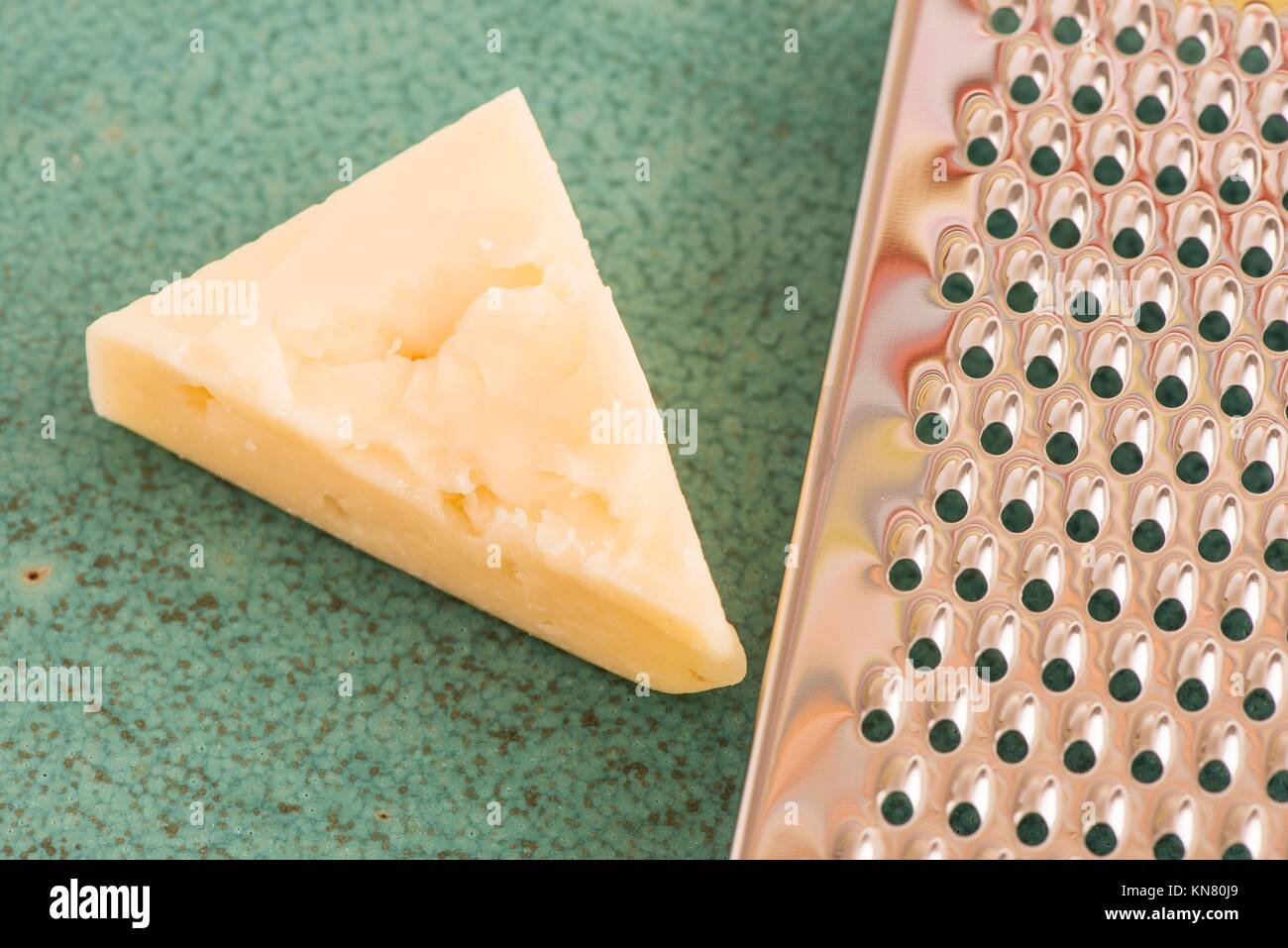 https://c8.alamy.com/comp/KN80J9/cheese-and-stainless-steel-grater-in-close-up-kitchen-appliance-used-KN80J9.jpg
