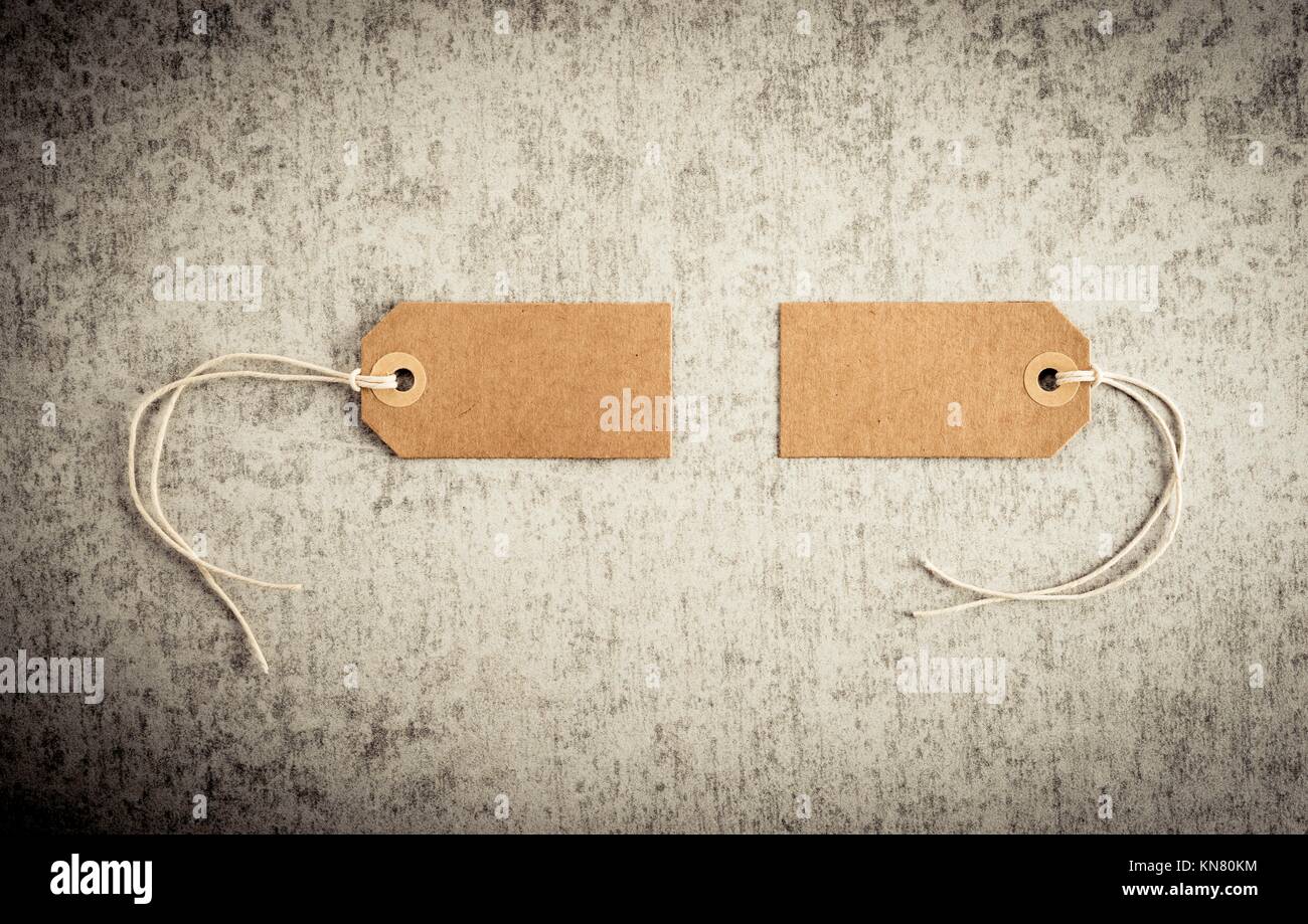 Two blank paper tags on stone background. Concept of sale, shipping or retail pricing. Stock Photo
