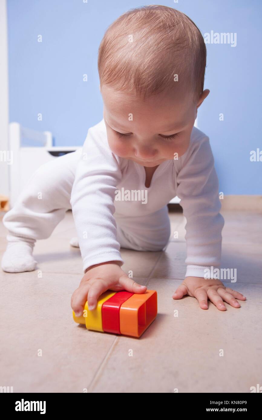 9 month baby boy playing with plastic building blocks. Selective focus. Stock Photo