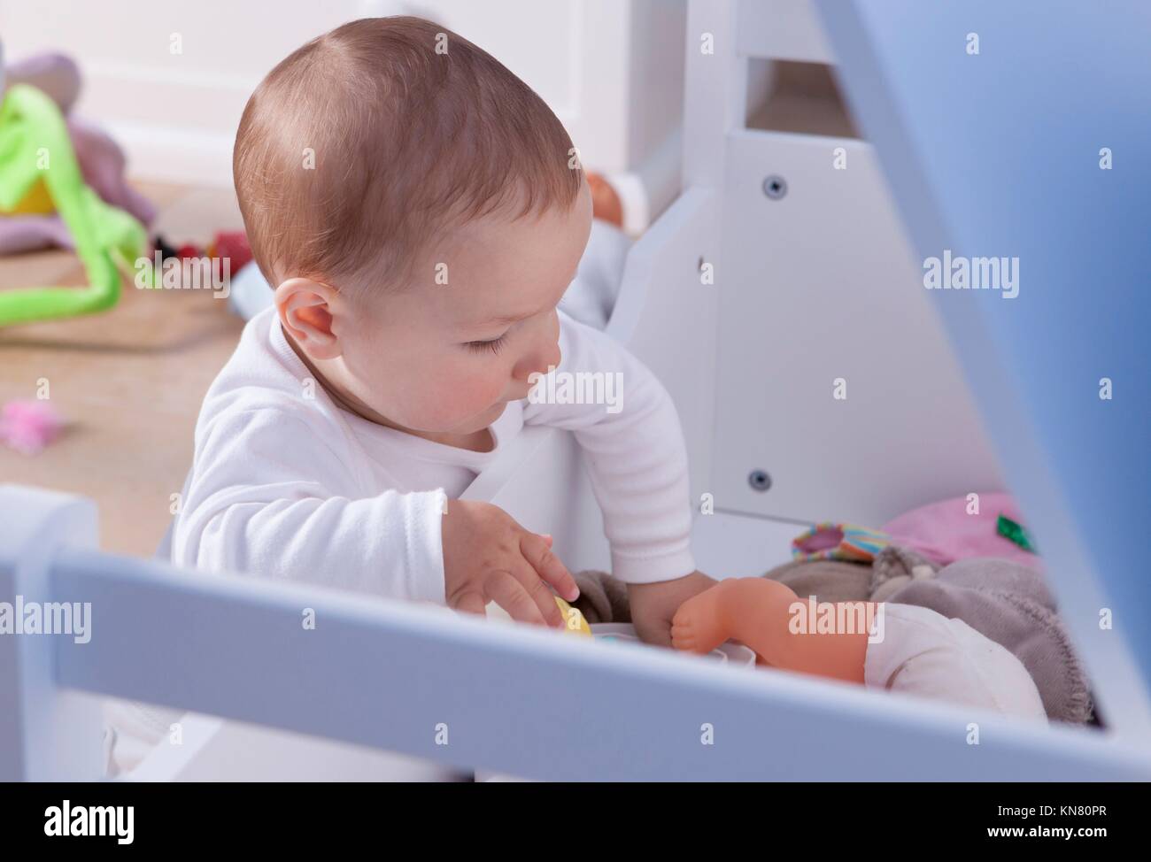 9 month baby boy playing with his white wooden toy trunk. Stock Photo
