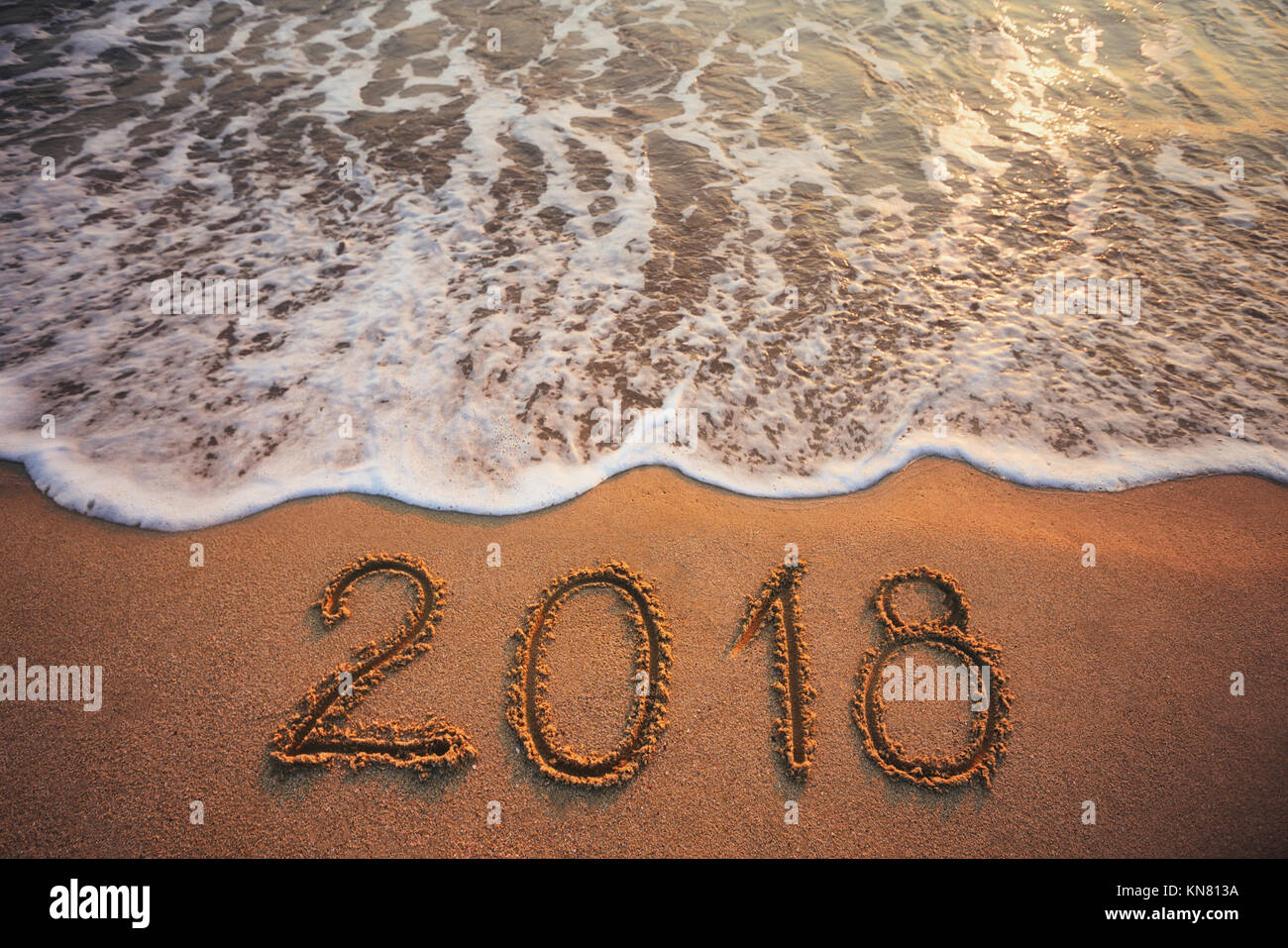 Happy New Year 2018 concept, lettering on the beach. Sea sunrise. Stock Photo