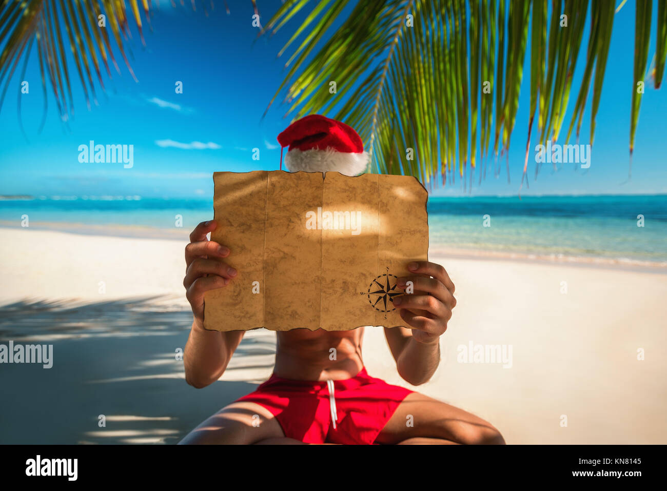 Tourist man with Santa Claus hat relaxing on tropical island beach. Punta Cana, Dominican Republic. Stock Photo