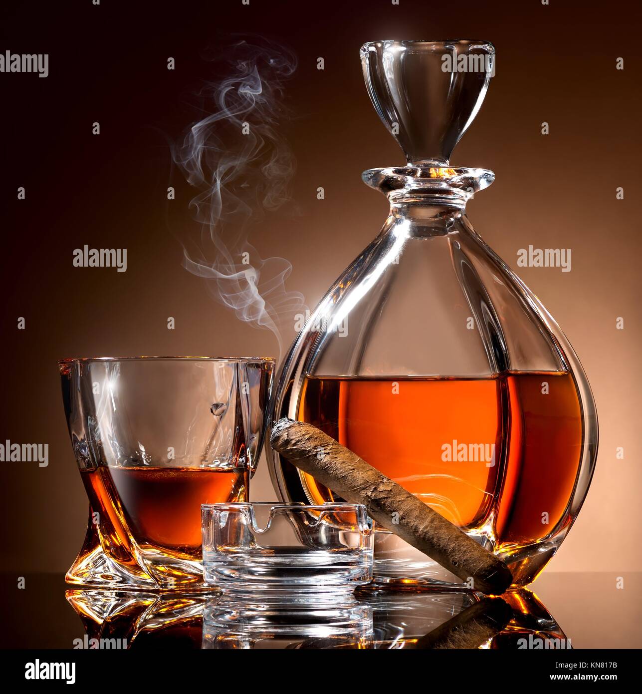Decanter abd glass of alcohol and cigar on ashtray. Stock Photo