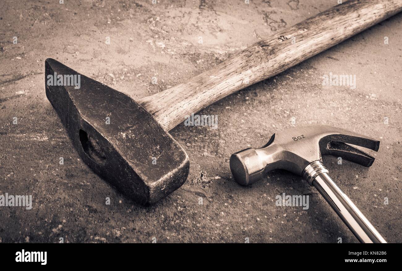 Hammer still life. Two hammers side by side on a stone workbench. Symbol of strength and force. Concept of industrial work tool, carpentry equipment Stock Photo