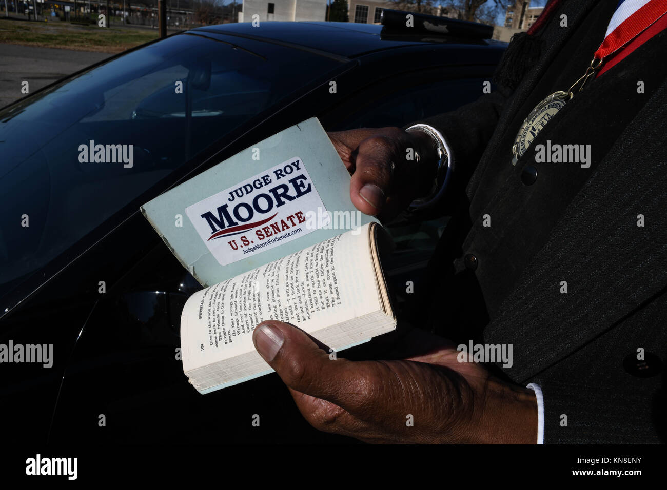 Birminham, Alabama, USA. 10th Dec, 2017. A member of the historic 16th Street Baptist Church shows the pro-Roy Moore sticker on the last page of his catechism booklet on the last Sunday before the divisive and pivotal U.S. Senate election between GOP candidate Roy Moore and Democrat Doug Jones, famous for prosecuted one of the KKK members convicted of bombing the downtown Birmingham church. The member, Mr. Wille Casey, said he considered himself 'colored' due to his mixed ethnic background, rather than black. Credit: Miguel Juarez Lugo/ZUMA Wire/Alamy Live News Stock Photo