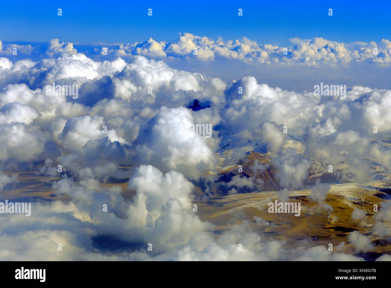 Aerial view mountains from airplane, clouds, sky. Stock Photo