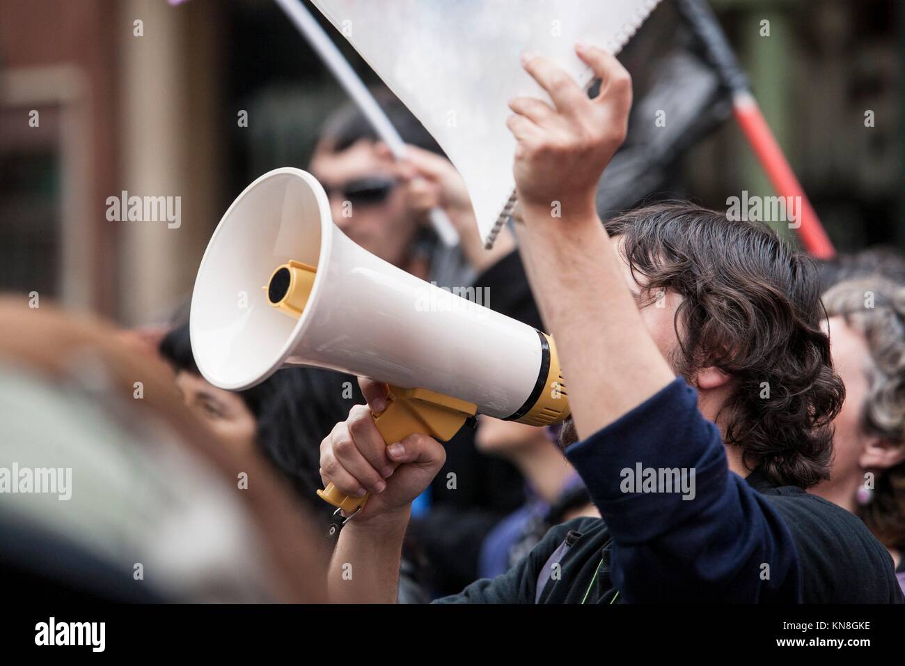 Unidentified young demostrator with megaphone and notebook protesting against austerity cuts. Stock Photo