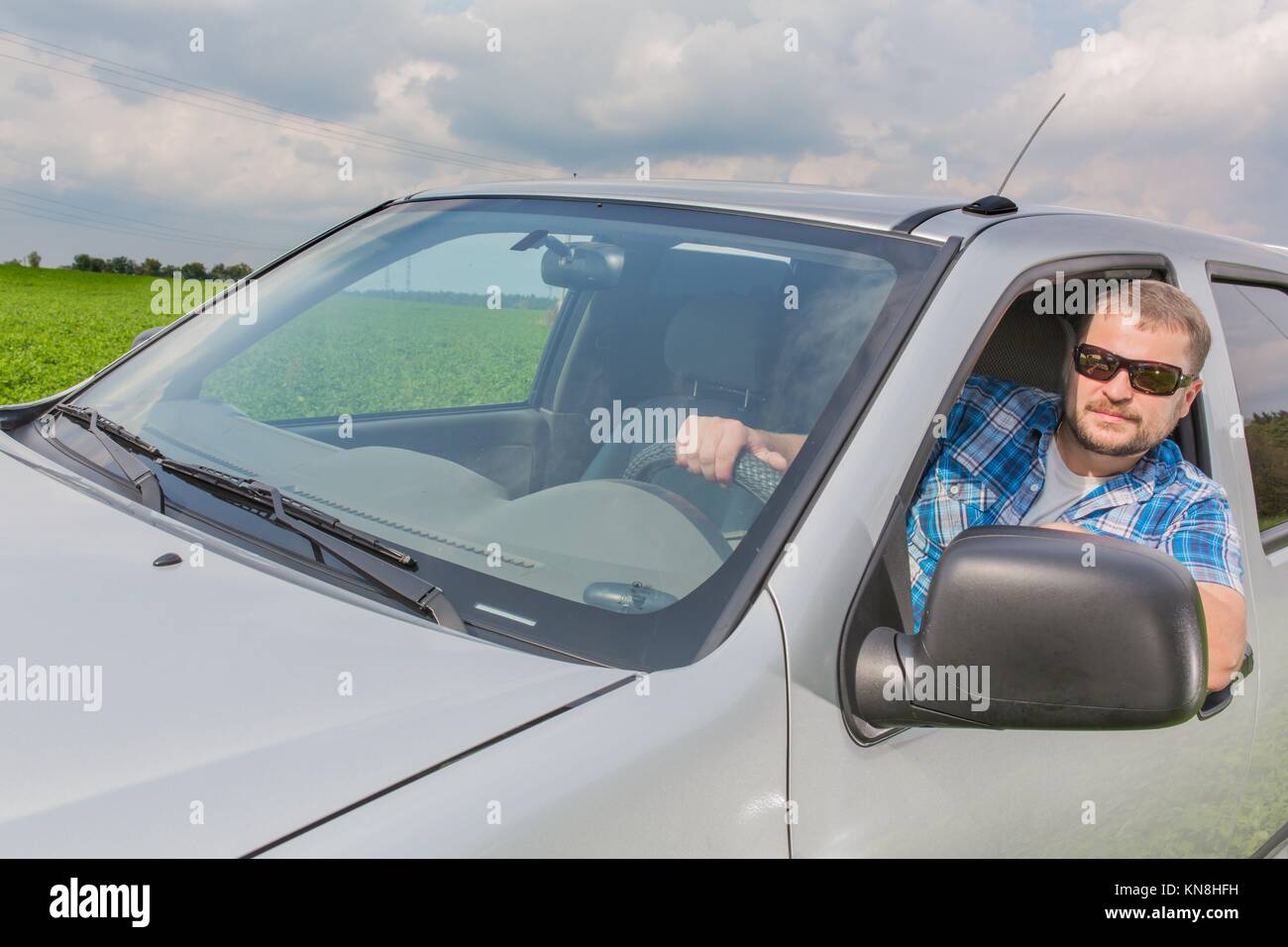 Man sitting in a car on driver's place and looking forward. Stock Photo