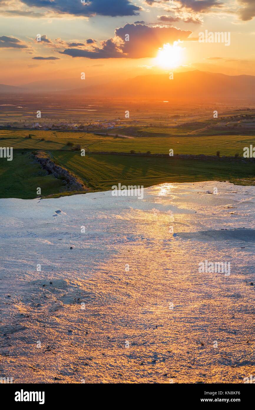 Sunset at the valley with glance surface on foreground. Stock Photo