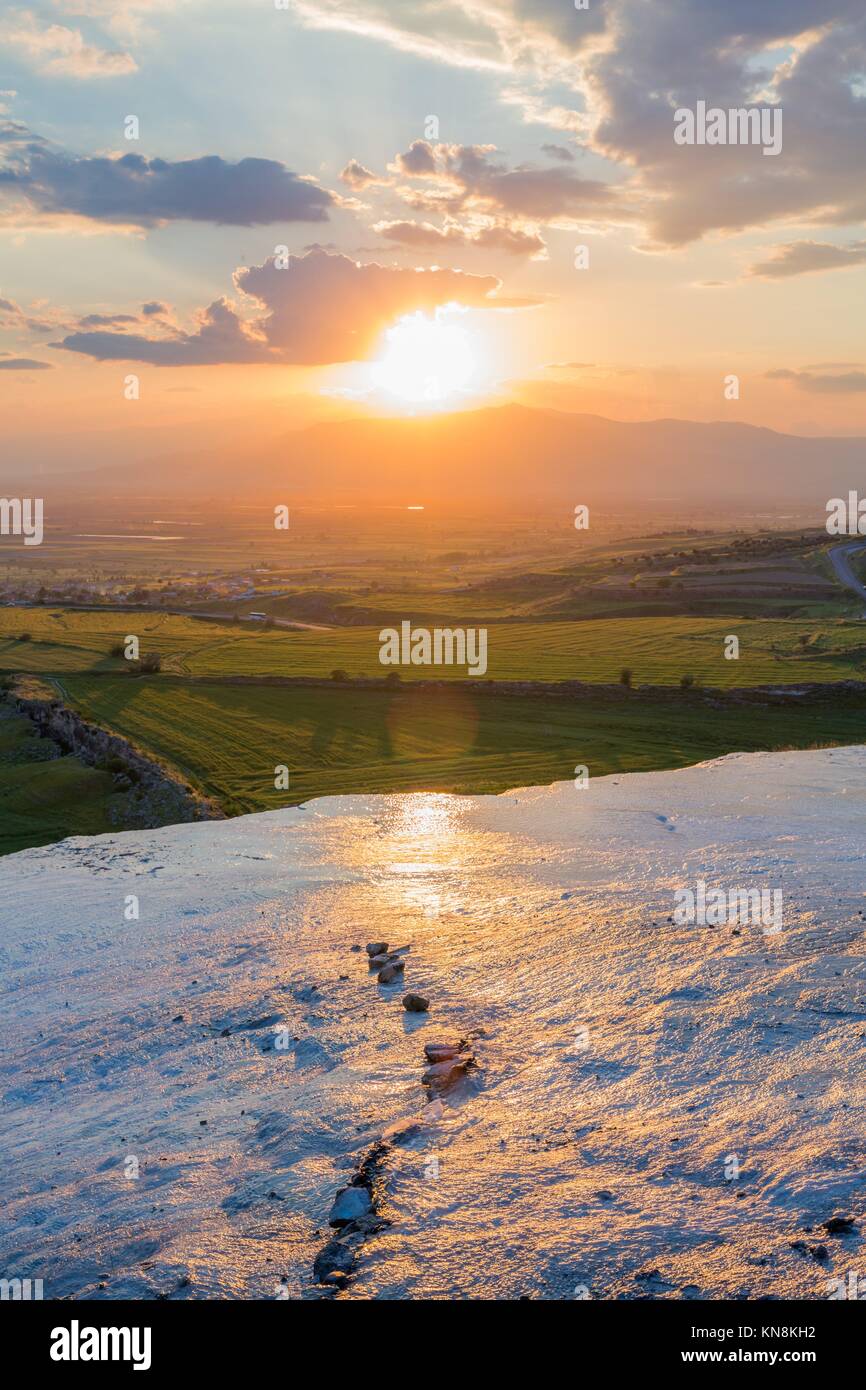 Sunset at the valley with glance surface on foreground. Stock Photo