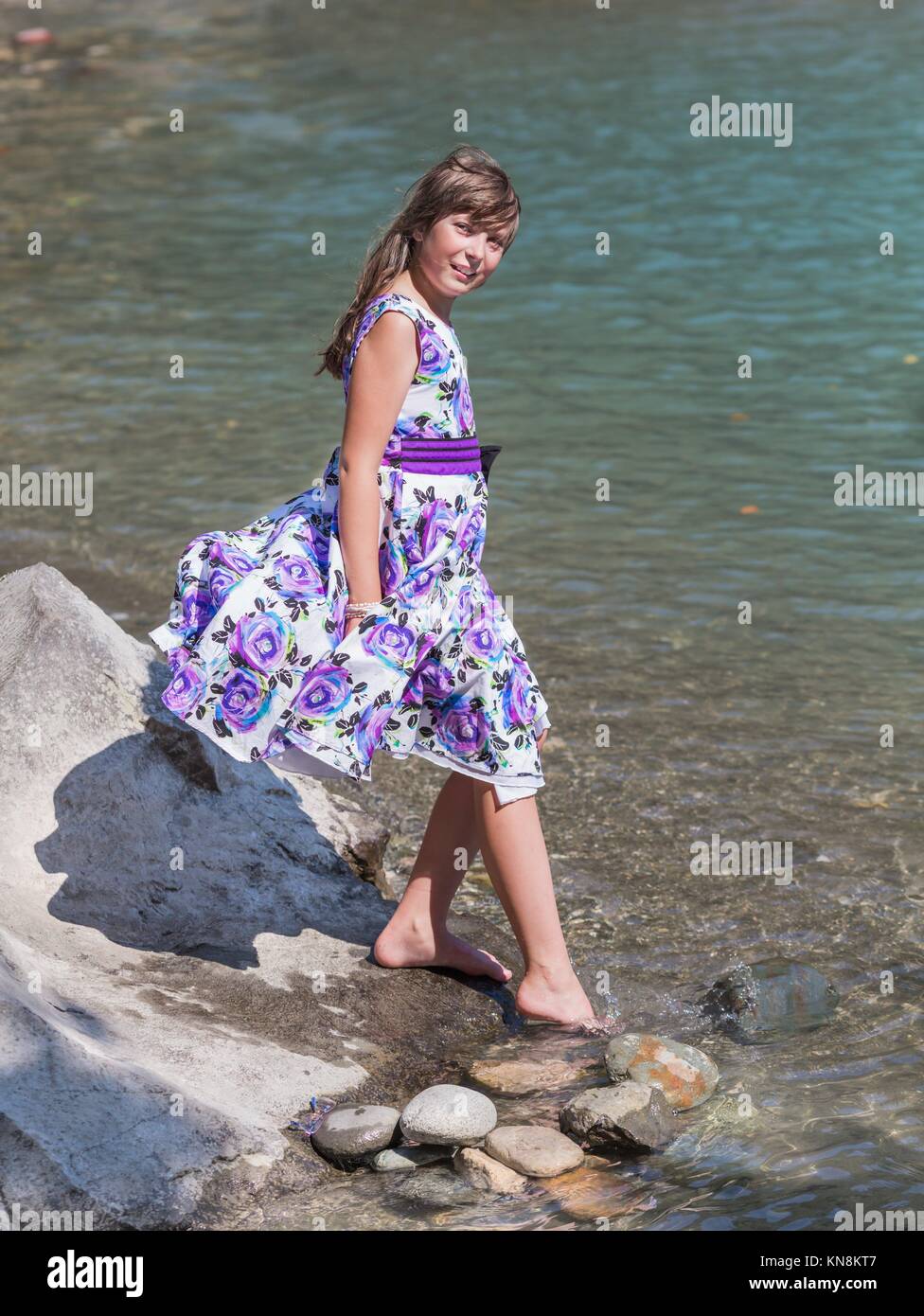 Cute preteen long hair girl posing on riverbank. Stock Photo