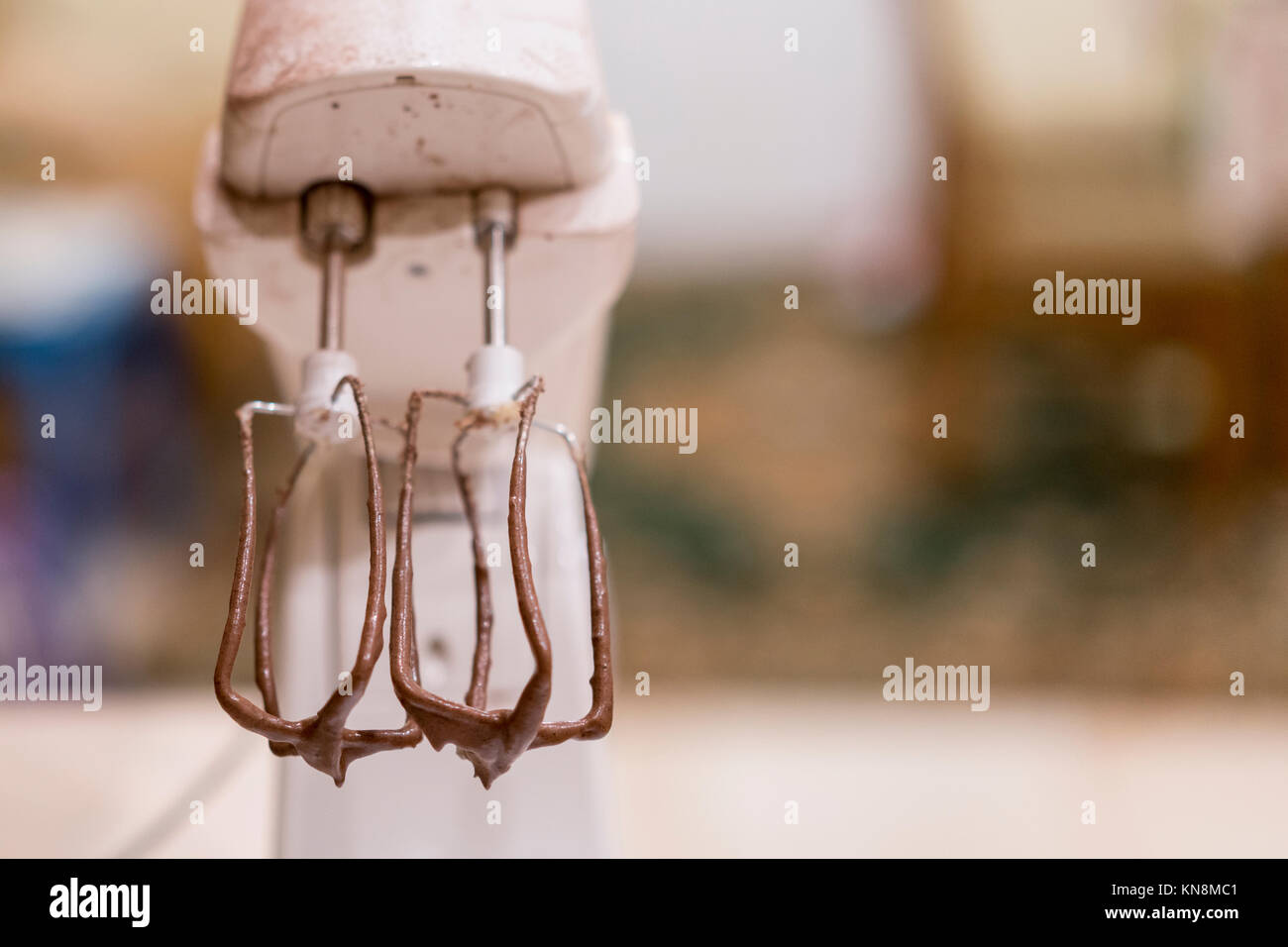 Brown dough inside industrial mixer. Dough pieces on mixer blade. Equipment at confectionery