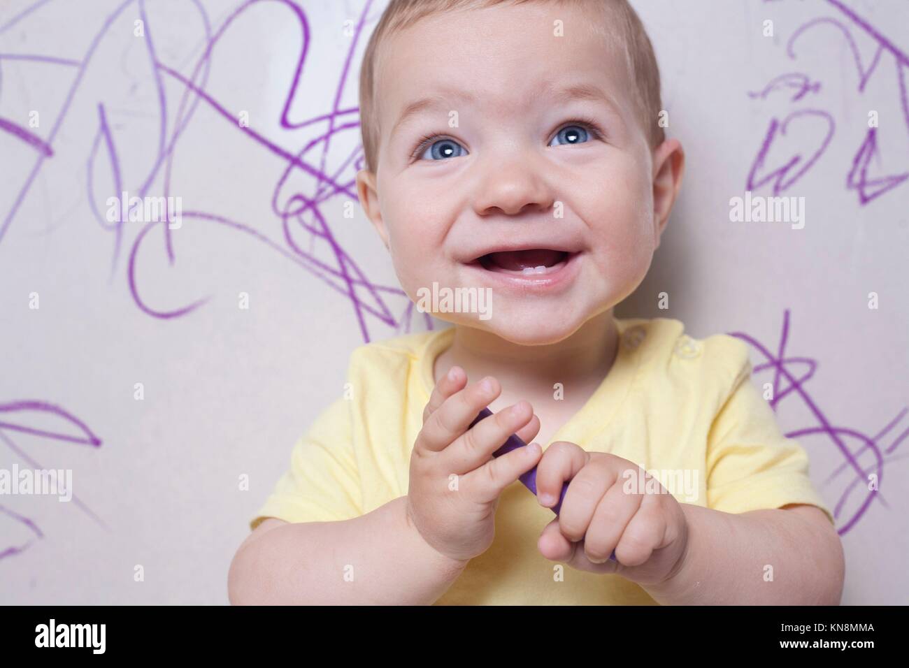 Smilling baby boy with wax crayon. He is looking to the camera. Stock Photo