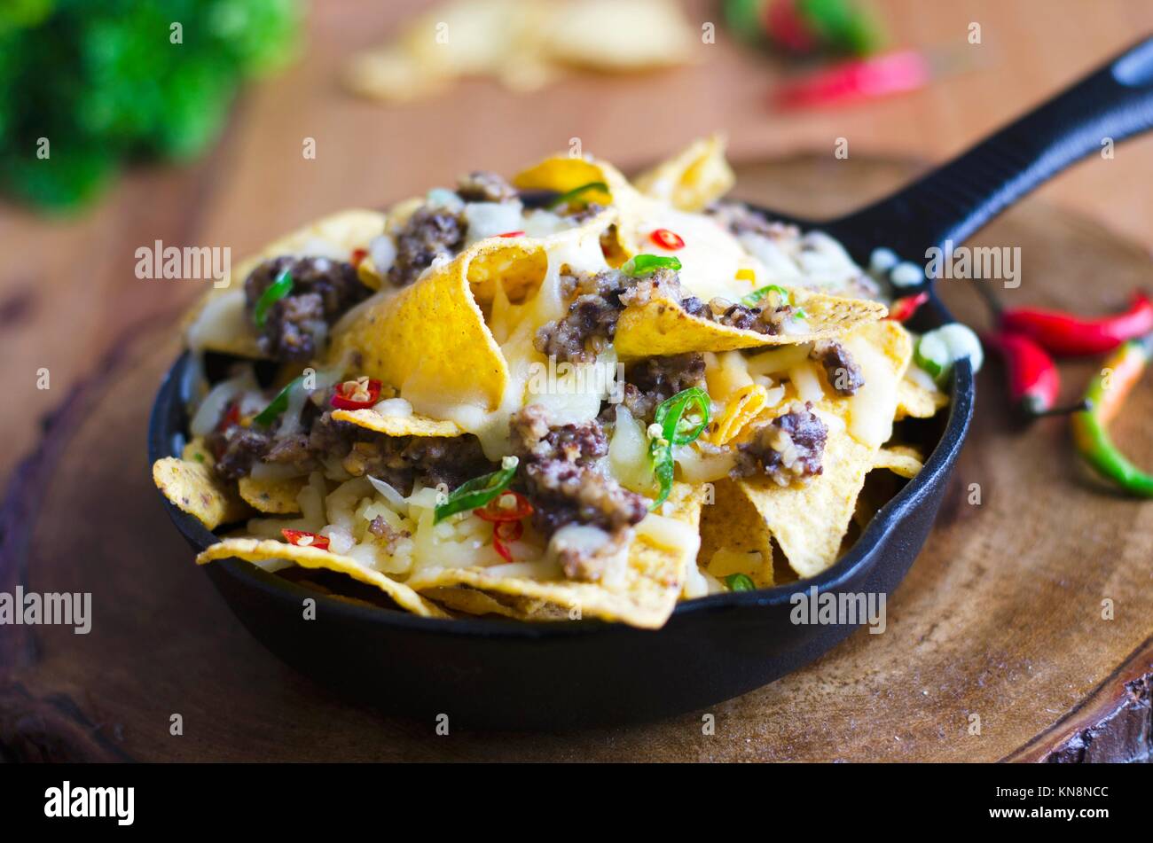 Nachos with haggis, melted cheese and chilli peppers. Stock Photo
