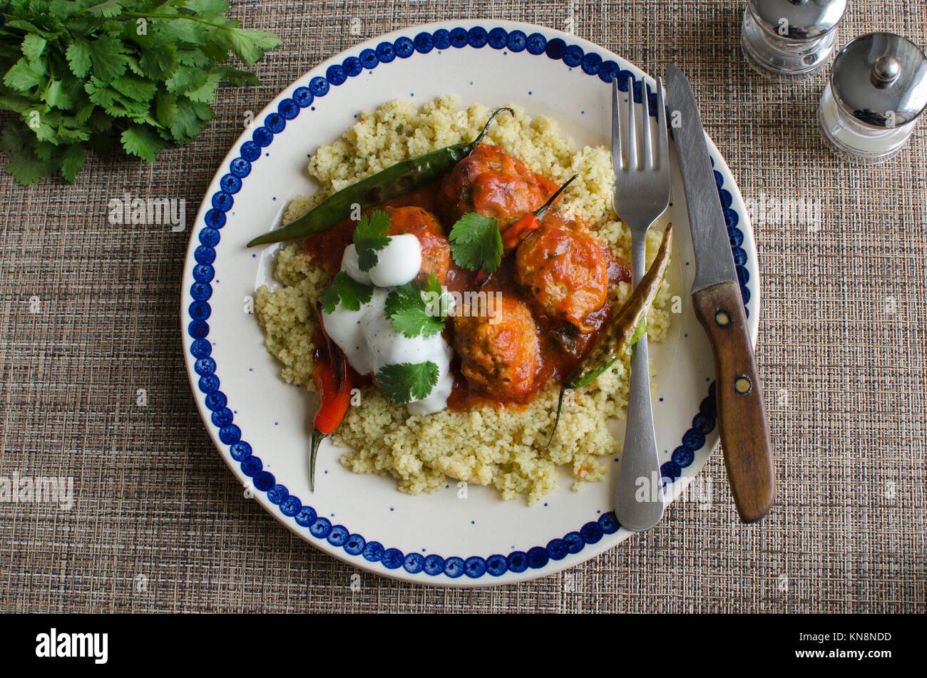 Meatballs in tomato sauce with couscous and chilli peppers Stock Photo