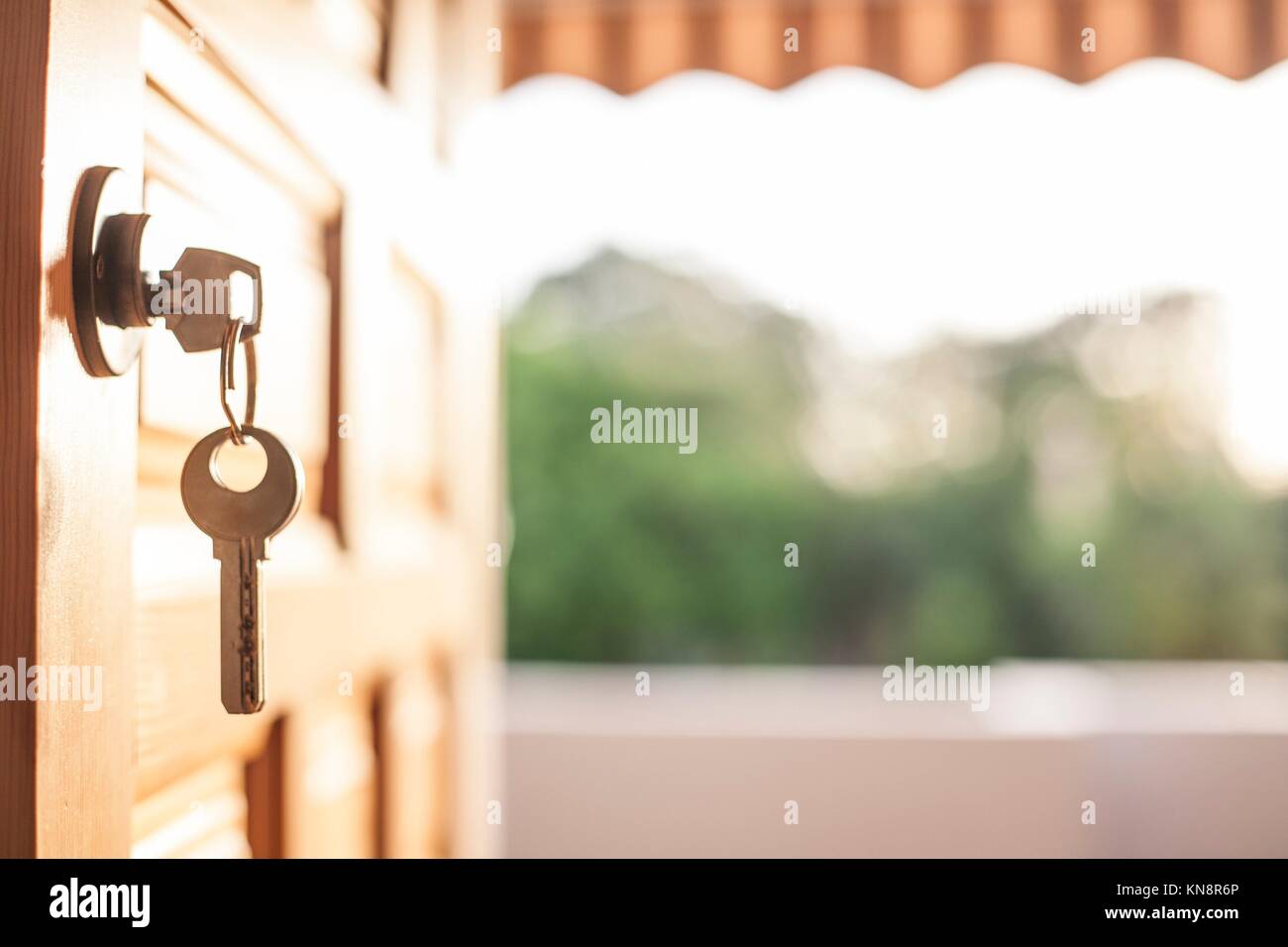 Keys hanging from the door with a nature background. Summer holidays in the country concept. Stock Photo