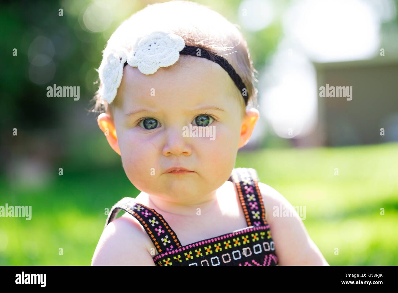 Baby girl at roughly 6 months old outdoors in a natural setting with