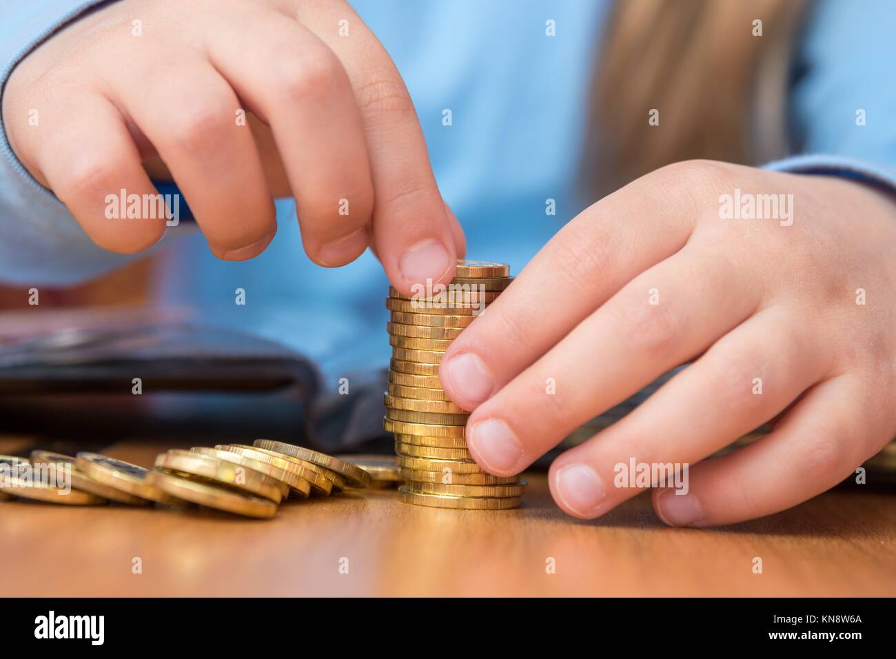 Child collects a stack of golden coins, closeup Stock Photo Alamy