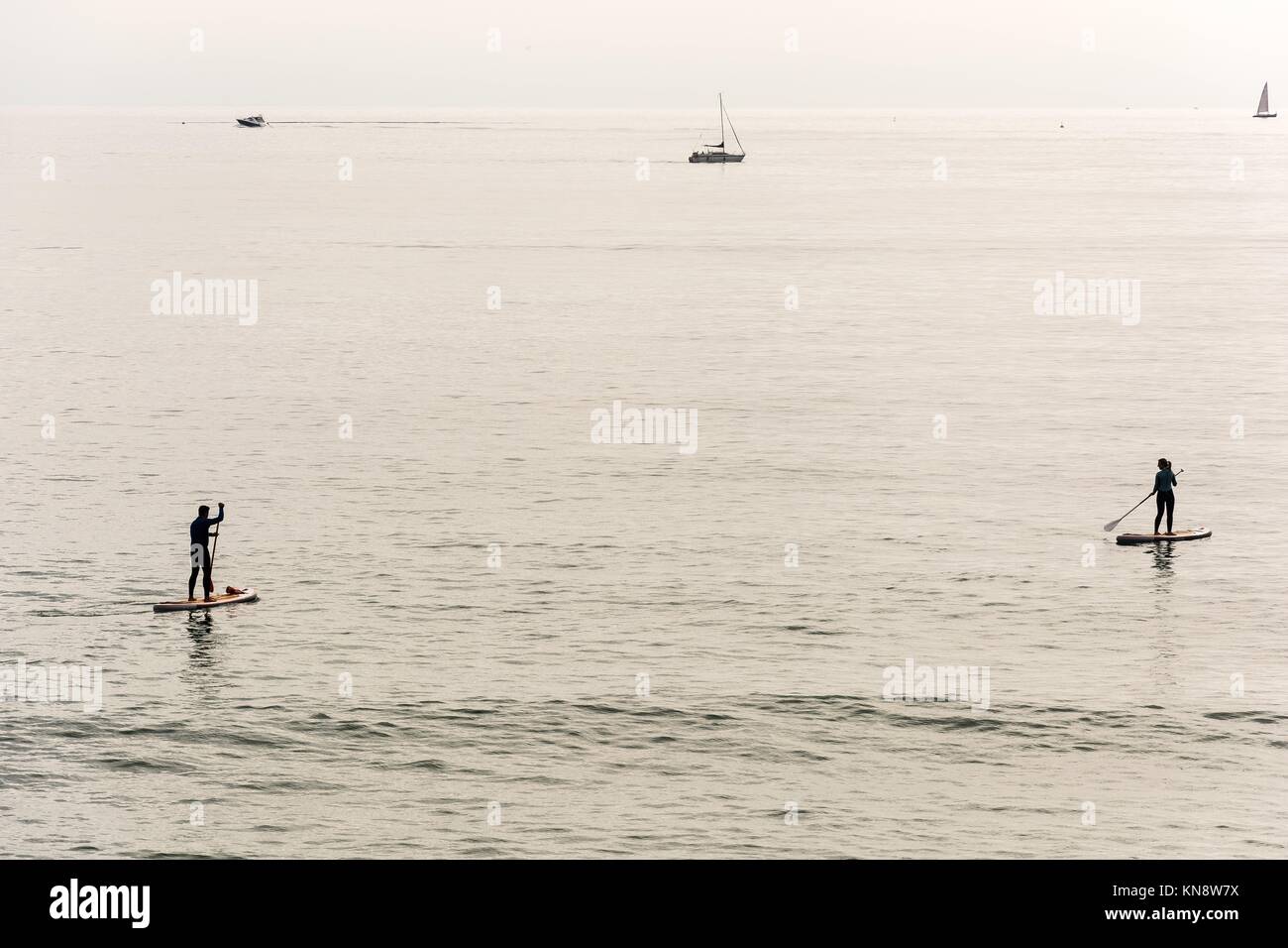 Couple practicing surf paddle on the Barcelona Coast. Stock Photo