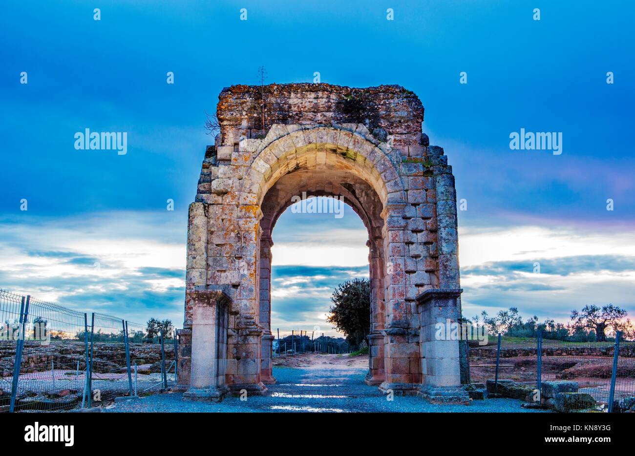 Roman Arch of Caparra at dusk, (1st-2nd century AD). Crossroad ancient city ruins at Silver Route, Via de la Plata, Caceres, Spain. Stock Photo