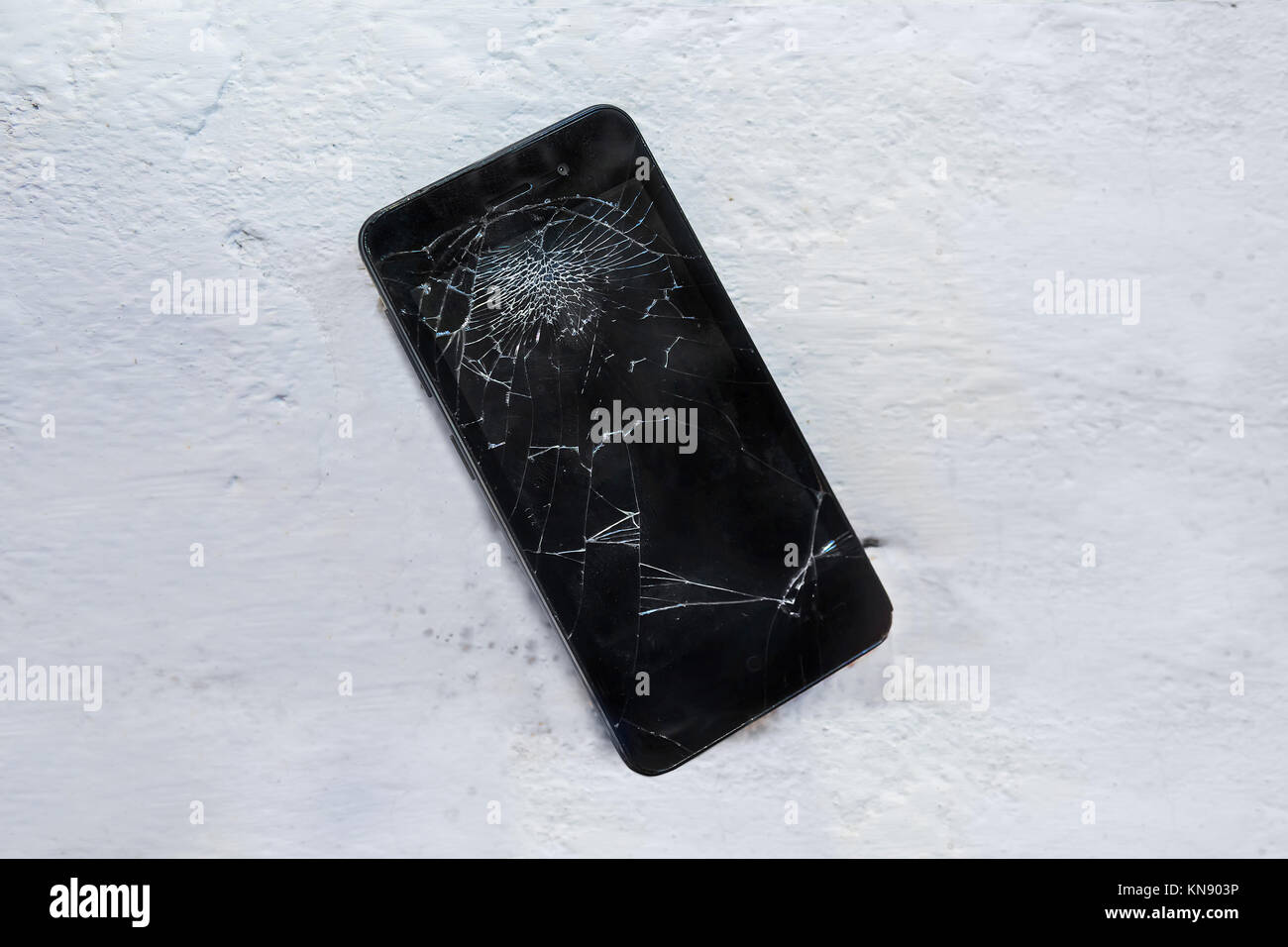 Black Modern phone fell on the concrete floor and shattered the screen