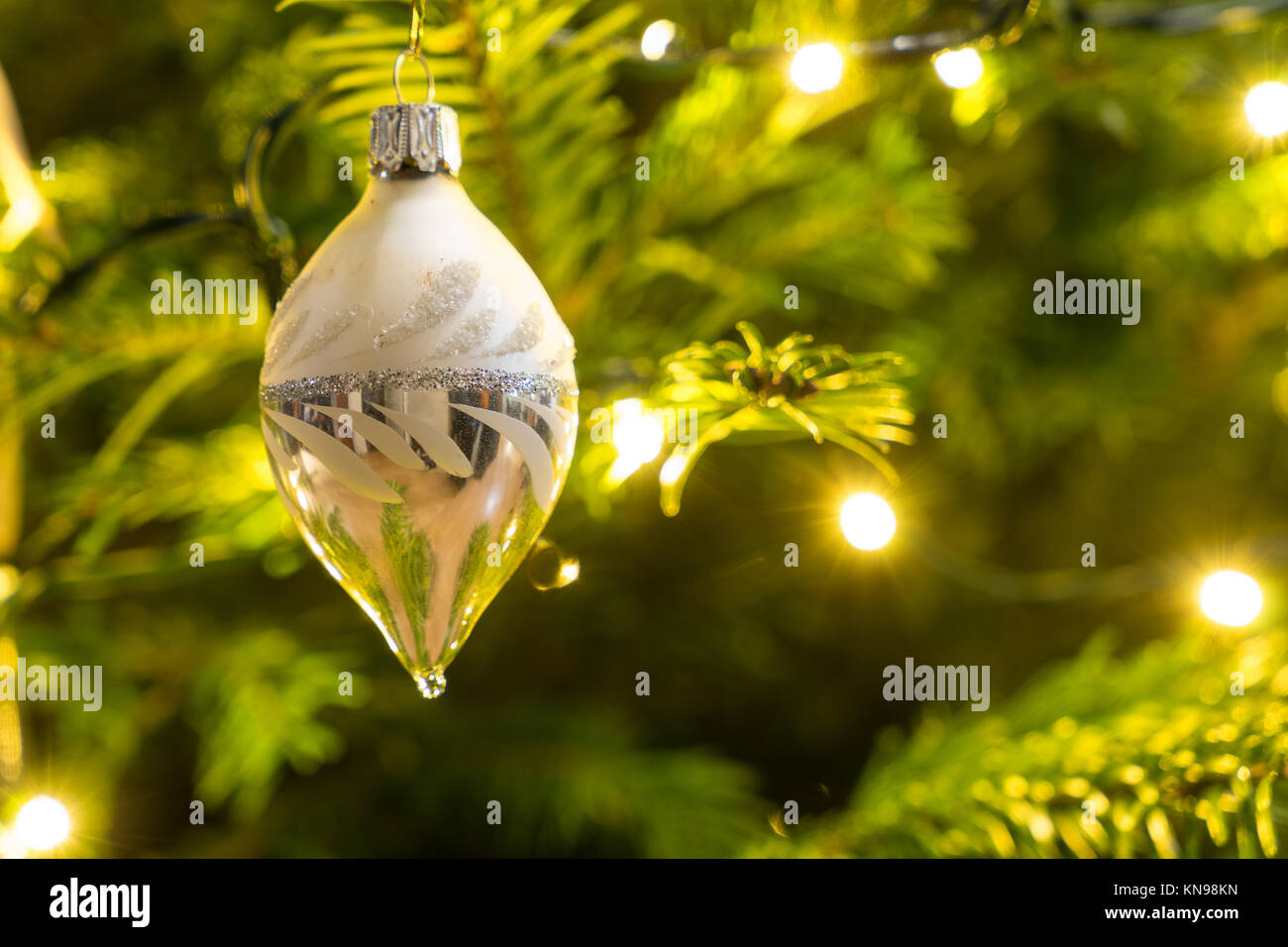 Christmas decoration white and silver cone hanging in a Nordman christmastree Stock Photo